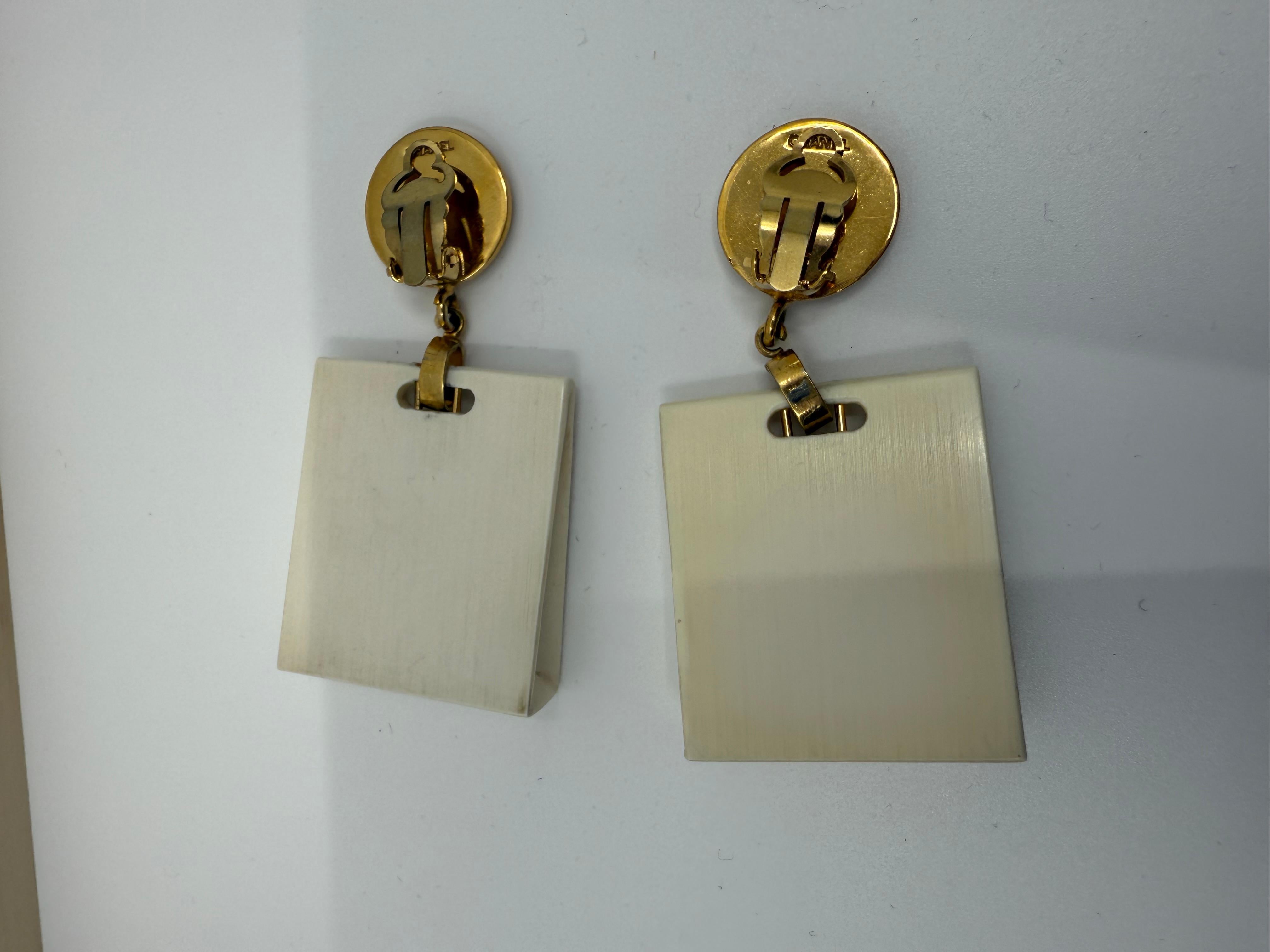 Diese verspielten Chanel-Ohrclips mit Wiedererkennungswert aus den 1980er Jahren haben die Form von Miniatur-Einkaufstüten und bringen eine Portion Pariser Charme und Witz in Ihre Schmucksammlung. Das Motiv der baumelnden Einkaufstasche aus