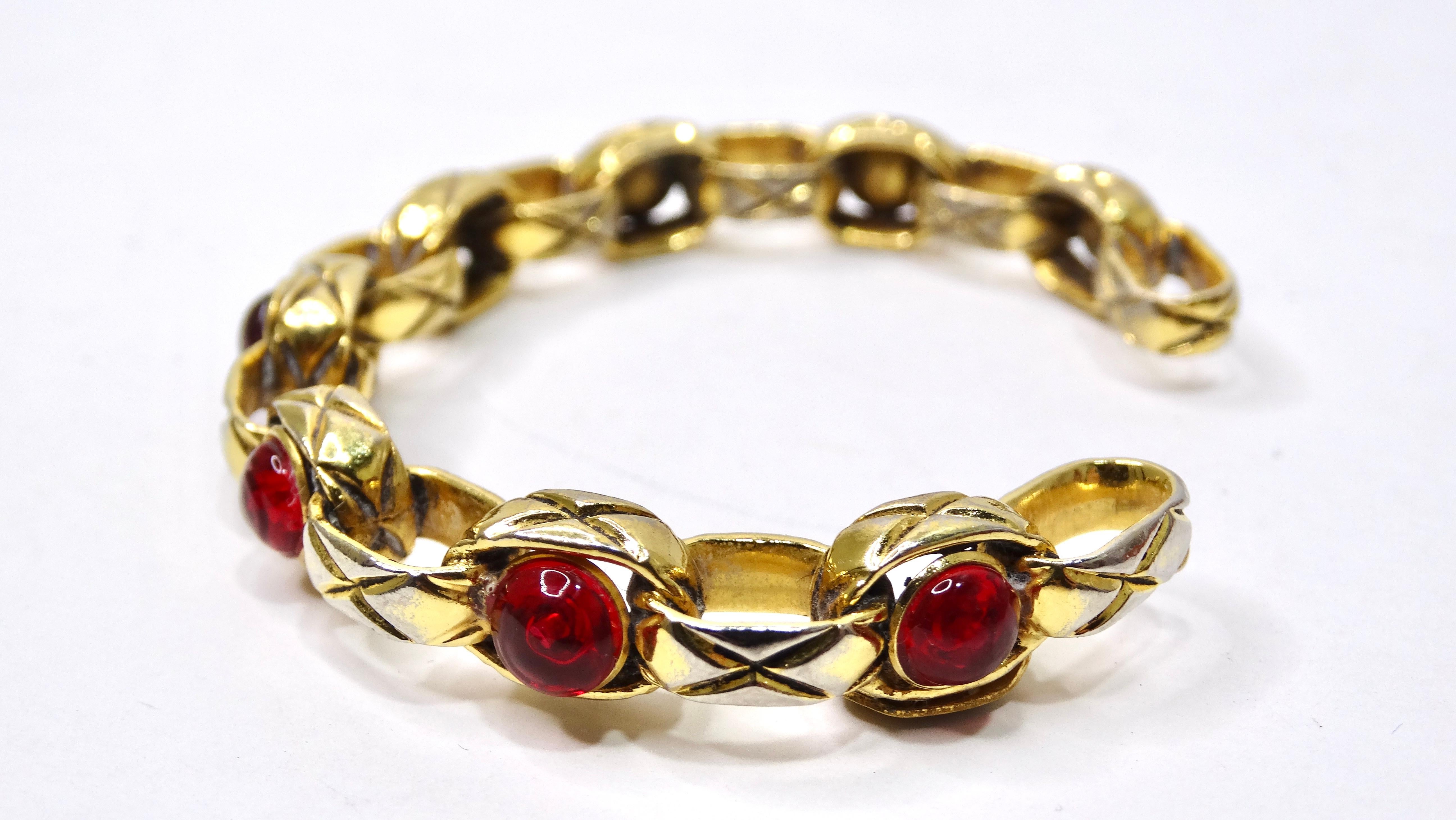This is a beautifully crafted Chanel cuff with great embellishments! It doesn't get better than this chain-link motif bracelet. It is adorned with red stones and has intricate engraving throughout. Pair this bracelet with some Yves Saint Laurent