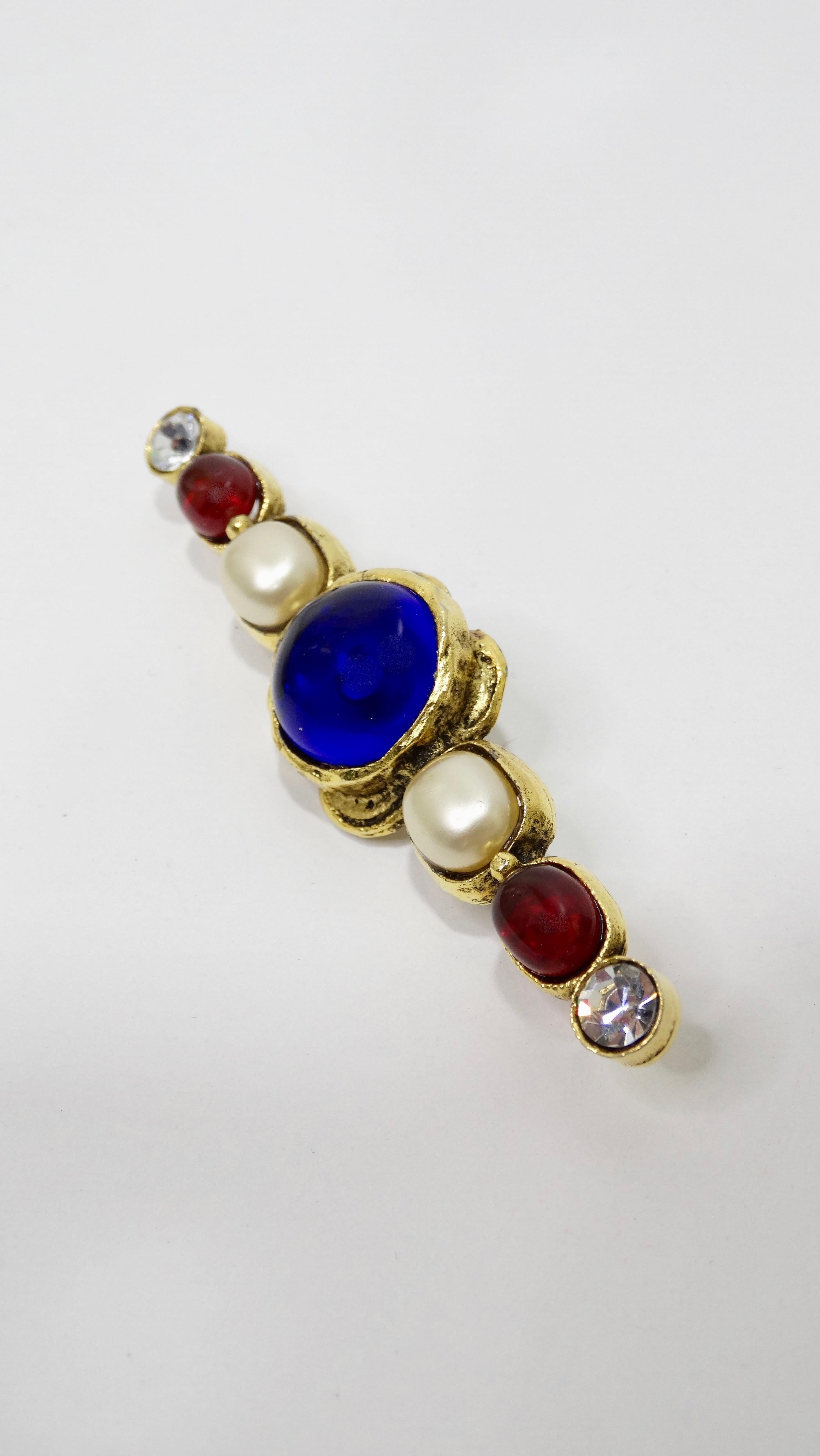 For the Chanel lover who doesn't want the CC! Circa 1984, this Chanel bar brooch is gold plated with a vintage finish and features royal blue and ruby red gripoix, faux pearls and rhinestones. Stamped Chanel 1985 on the back. Timeless and chic, this