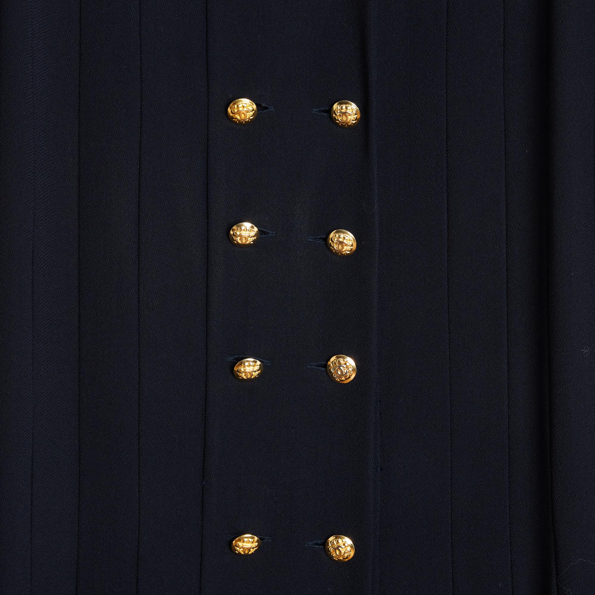 Chanel trench coat or long dress circa 1985 by Karl Lagerfeld (Inès de la Fressange period) in black wool crepe, straight cut pleated at the bottom, collar closed by a first high button (hidden under the collar and inside) and double-breasted (10