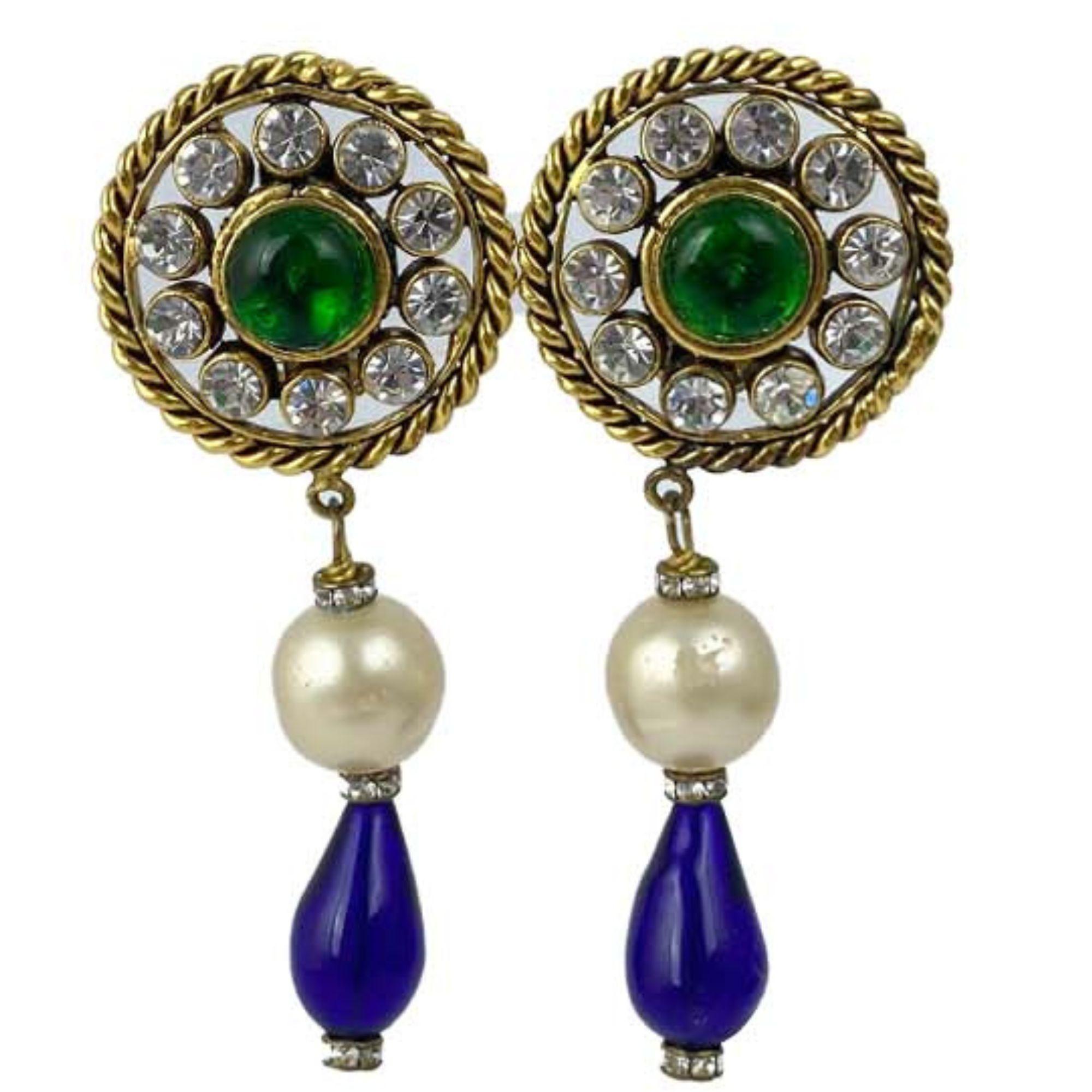 Vintage Chanel GOLD/BLUE/GREEN 1986 Gripoix LG clip on dangle earrings featuring emerald green gripoix glass domed cabochon surrounded by 10 sparkling clear crystals. In great condition with minimal signs of wear and repairs have been made to one of