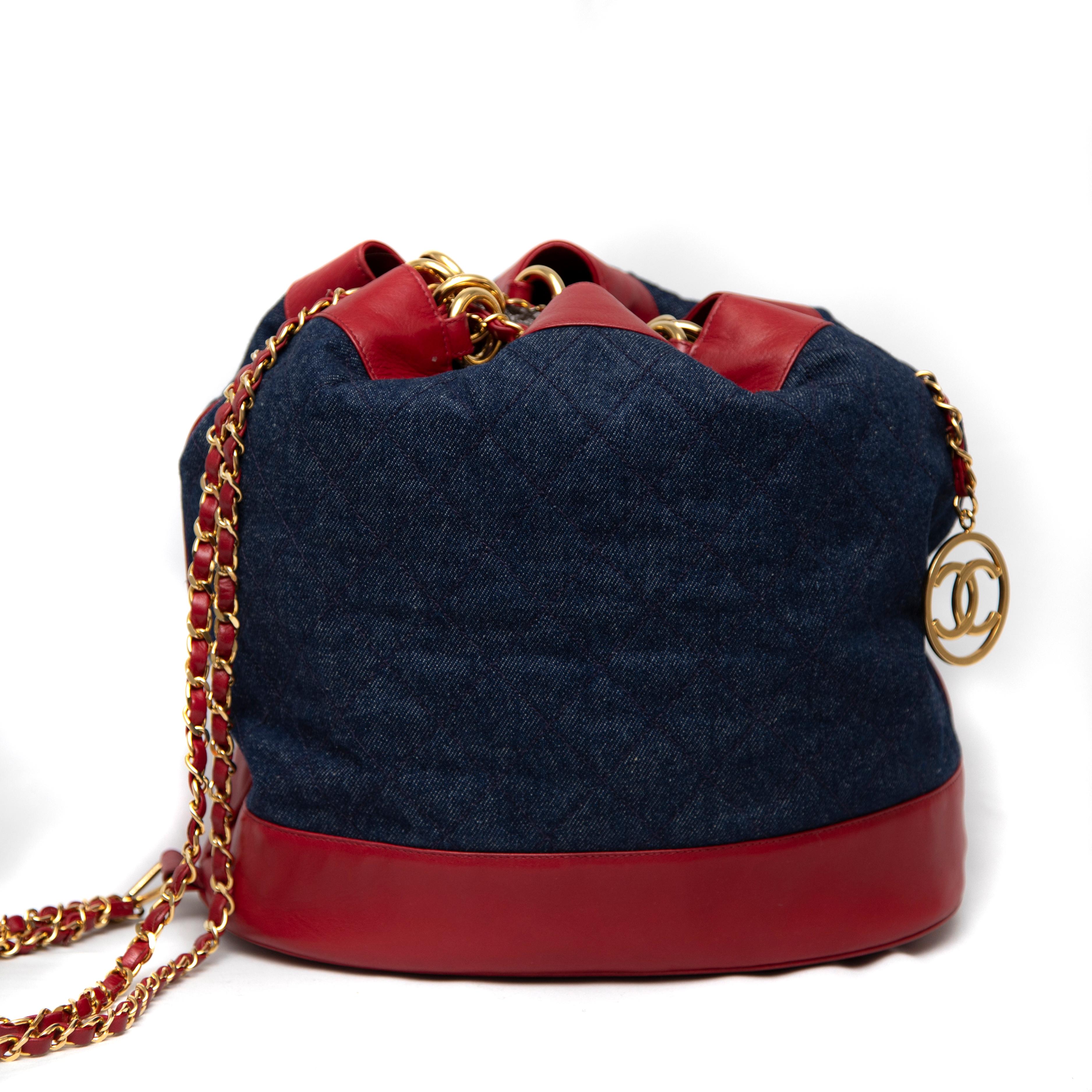 The Chanel 1989 Quilted Denim and Red Lambskin Leather Bucket Bag is a unique and stylish accessory that captures the essence of Chanel's timeless elegance with a playful twist. This vintage piece features a striking combination of soft, quilted