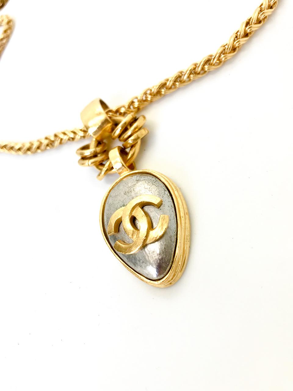 Chanel 1990s (1997 A) 24 Karat Gold Plated Pendant Necklace on chunky gold plated chain.  The iconic CC logo is emblazoned in gold plate on the silver coloured pendant. 

Designed for the 1997 Autumn Winter Collection, this piece is so evocative of