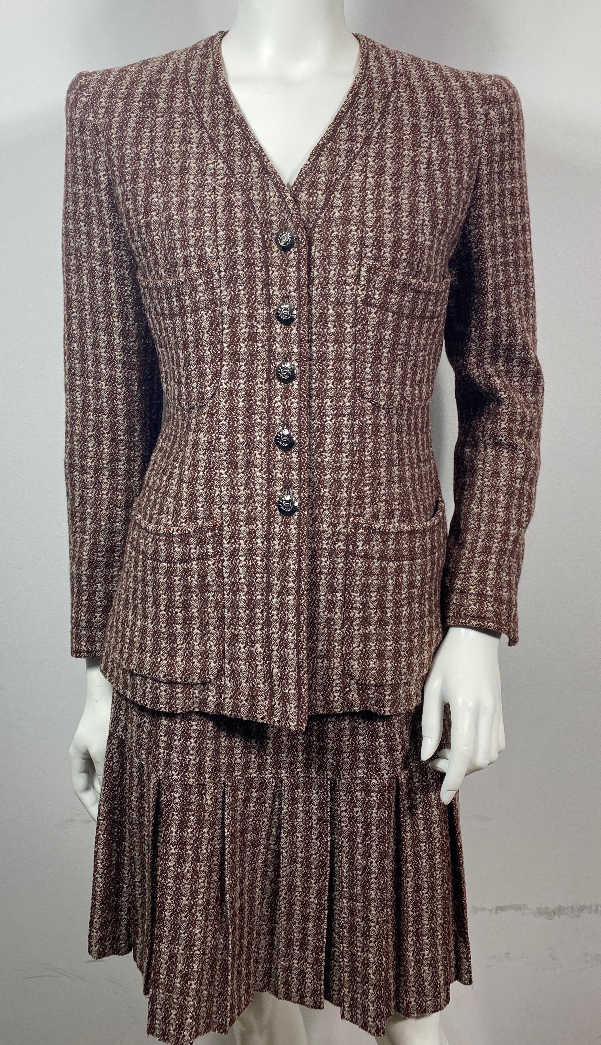 Chanel 1990’s Brown and Crème Wool Nailshead Tweed Skirt Suit-size 36  This 1997 Single Breasted skirt suit has a jacket with a subtle V neckline that is fully lined with silk CC logo fabric, has a platinum chain at the inside bottom of the jacket,