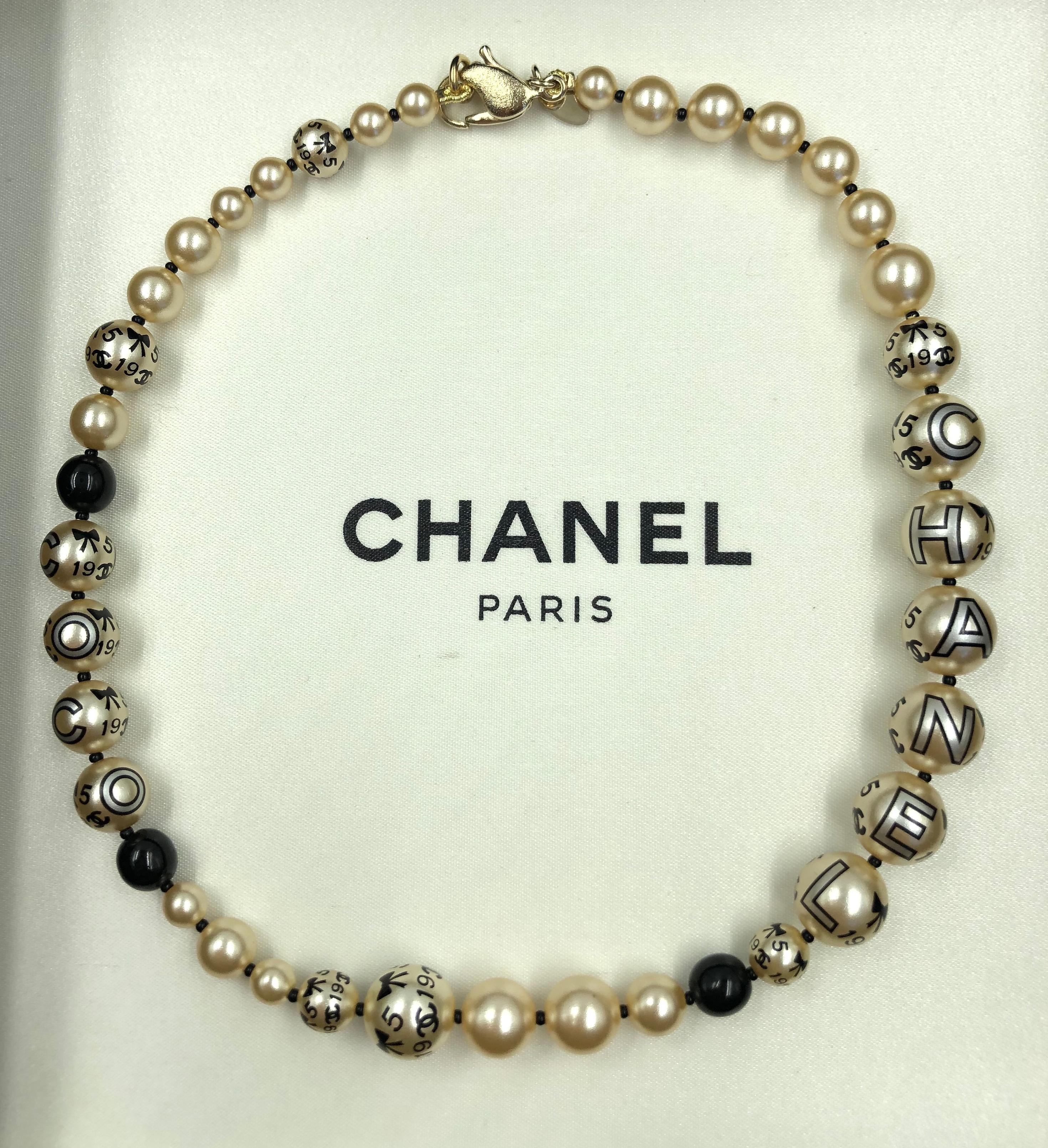 Chanel 1990's Faux pearls with Coco Chanel Print on Strand
Necklace comes with original box.

Length: 15