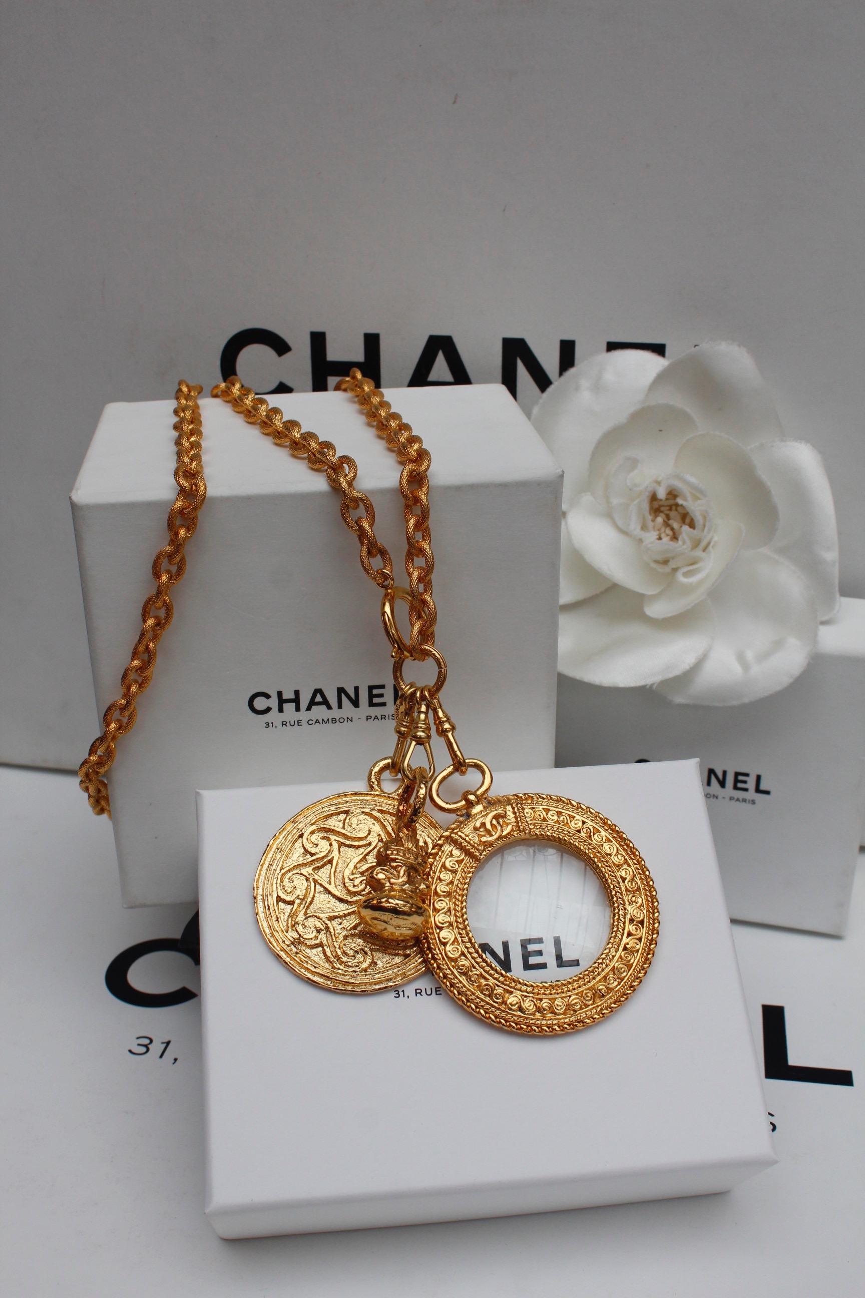 CHANEL (Made in France)

Nice gilted metal chain necklace adorned with a coin, a seal and a magnifying glass pendants in a Byzantine inspiration.

Signed on a plate next to the clasp.

From the 1990s.

Length : 33 in - Maximum pendant's length: 3.5