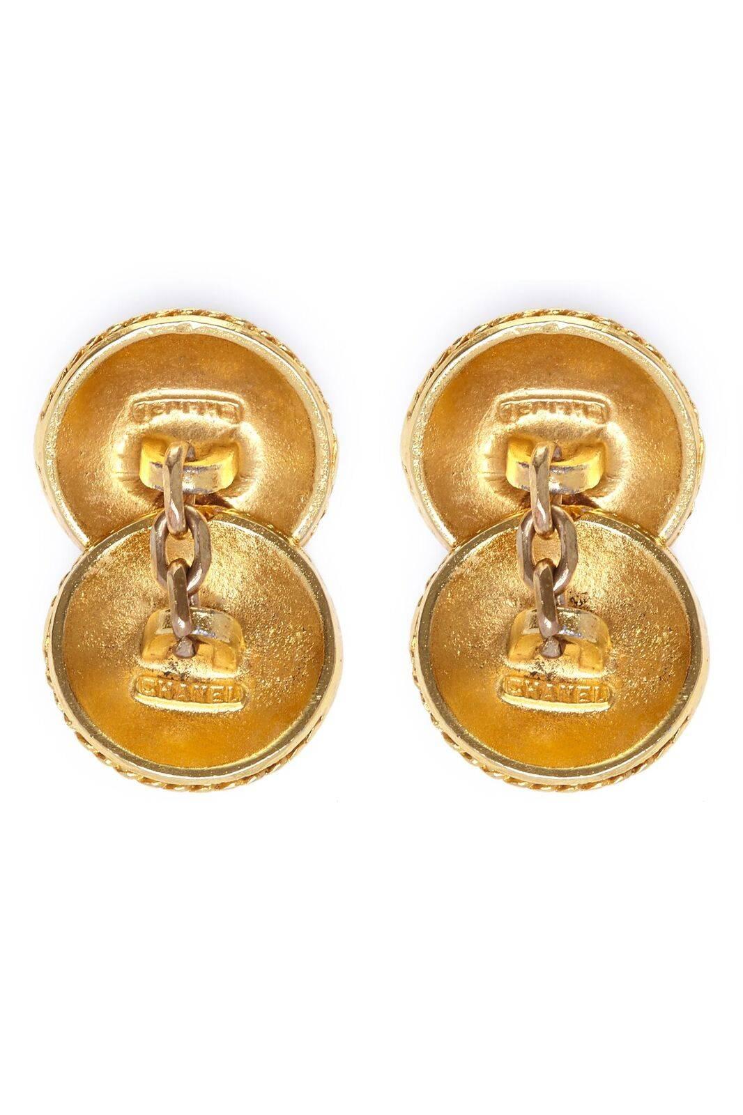 These classic 1990s Chanel gold gilt cufflinks are emblazoned with the signature double CC motif and feature a 3 link chain detail per piece. Each round carries the designer's signature on the reverse and measures 0.6