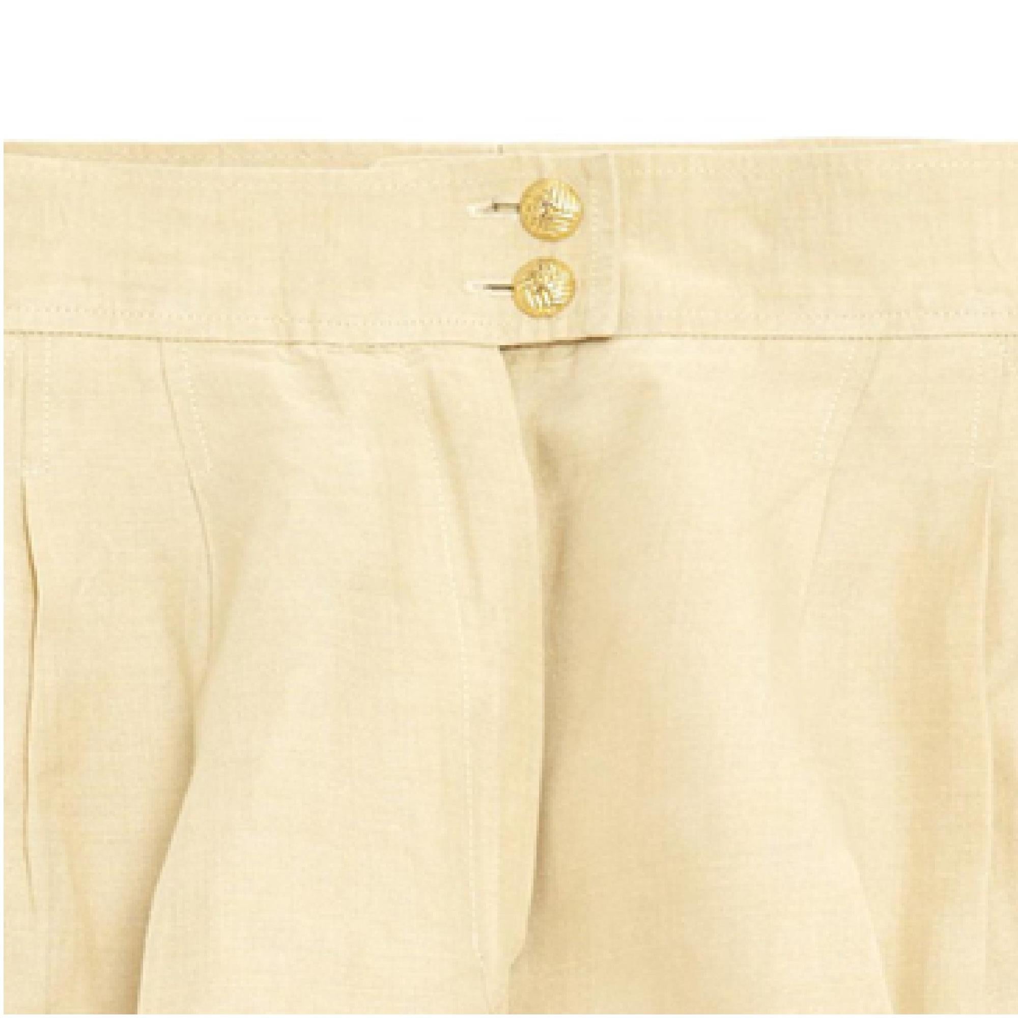 Pantaloncini Chanel, bermuda a pieghe larghe e corte in lino beige (e seta o cotone?), vita alta, 2 tasche a fessura sul lato, 2 tasche con bottone sul retro, ampia cintura a vita alta chiusa da 2 bottoni in metallo dorato, fodera in seta abbinata.
