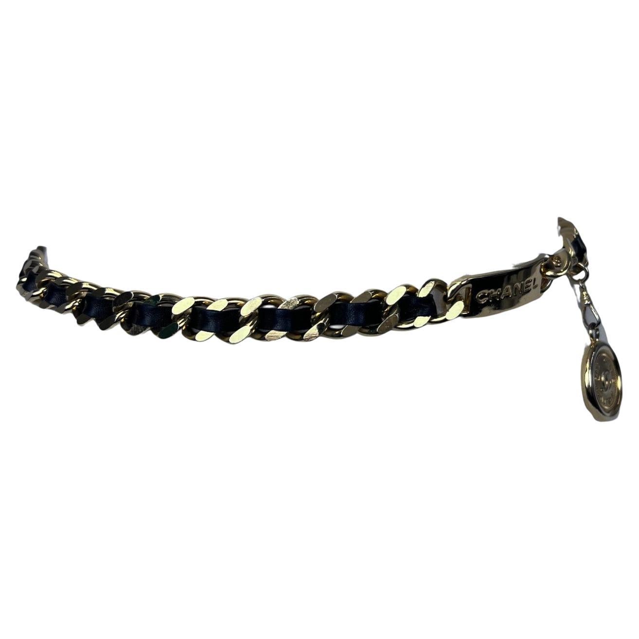 Un pezzo forte degli anni '90, questa cintura a catena con targhetta e medaglione di Chanel incarna l'audace glamour dell'epoca. Realizzata in metallo dorato, la cintura presenta una targhetta Chanel sovradimensionata che trasmette sicurezza e