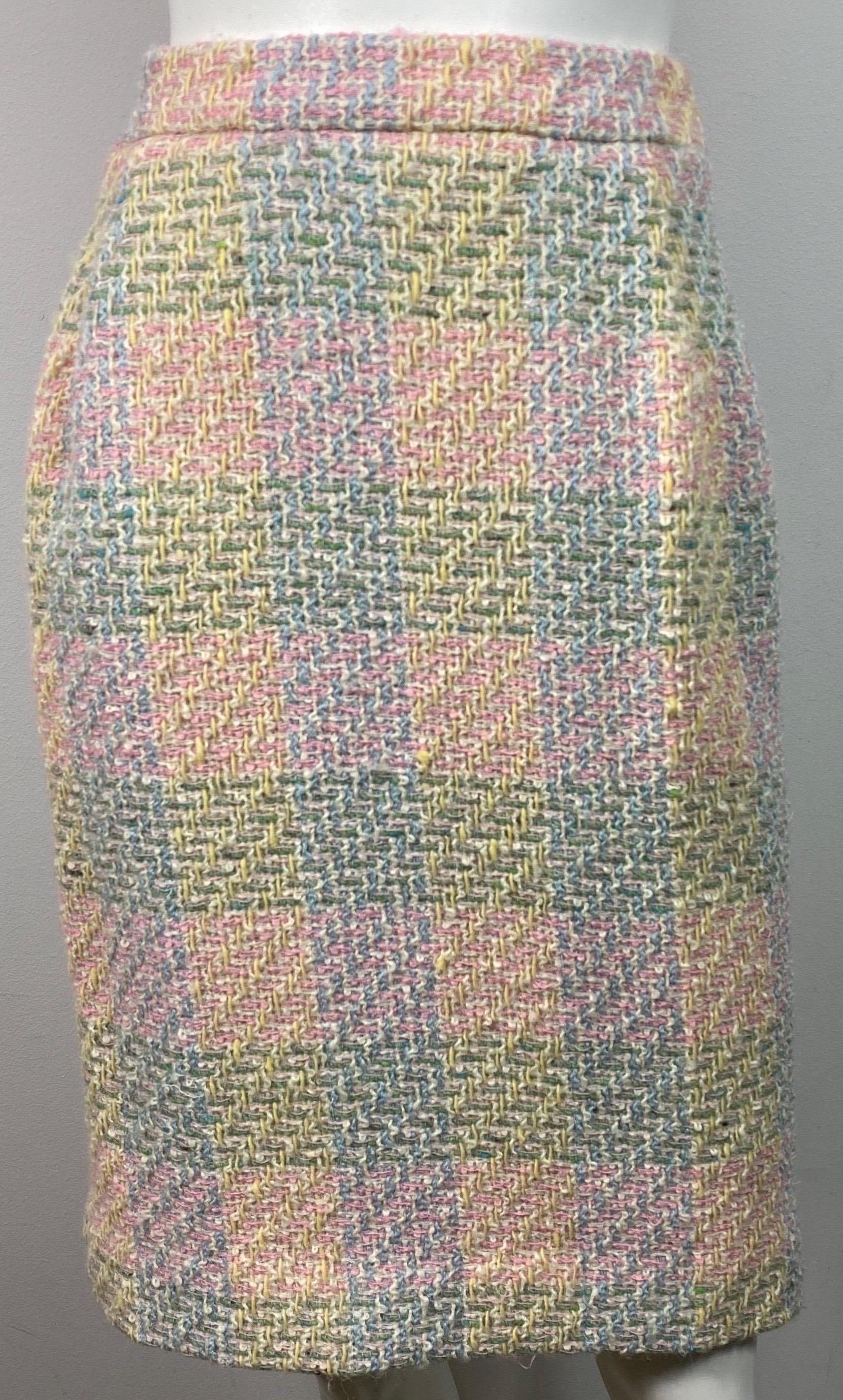 Chanel 1990’s Pastel Boucle Tweed Skirt - Size 42  This classic 1990’s skirt is made of a Pink, Yellow, Green and Light Blue Boucle Tweed and is lined in a light blue silk. The skirt has a 9” zipper with a hidden button and 1 Gold Chanel button at