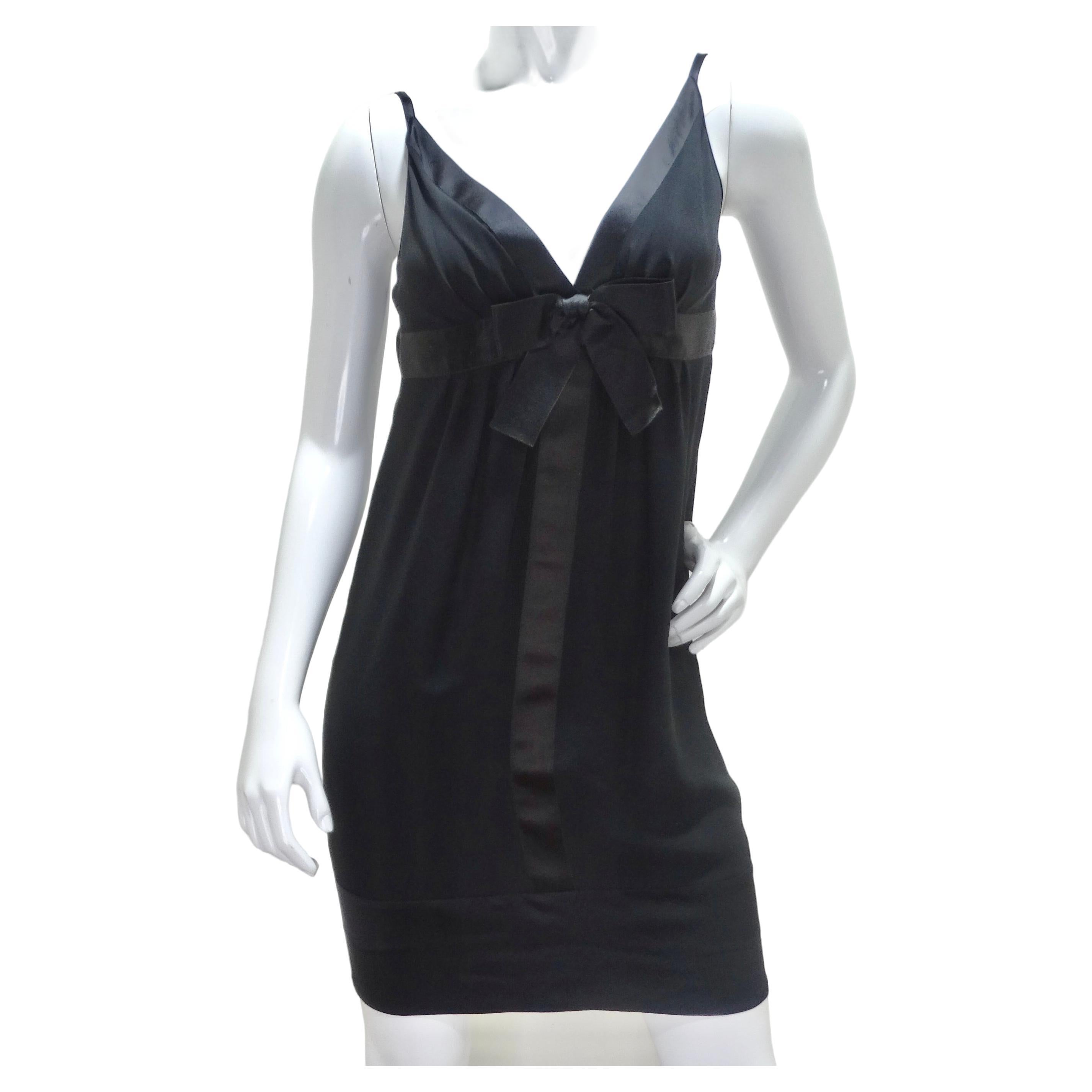Der Inbegriff zeitloser Eleganz - das Chanel 1990s Silk Bow Motif Little Black Dress. Dieses schwarze Midikleid aus Seide ist nicht nur ein Kleidungsstück, sondern ein tragbarer Ausdruck von Raffinesse und Weiblichkeit. Stellen Sie sich selbst in