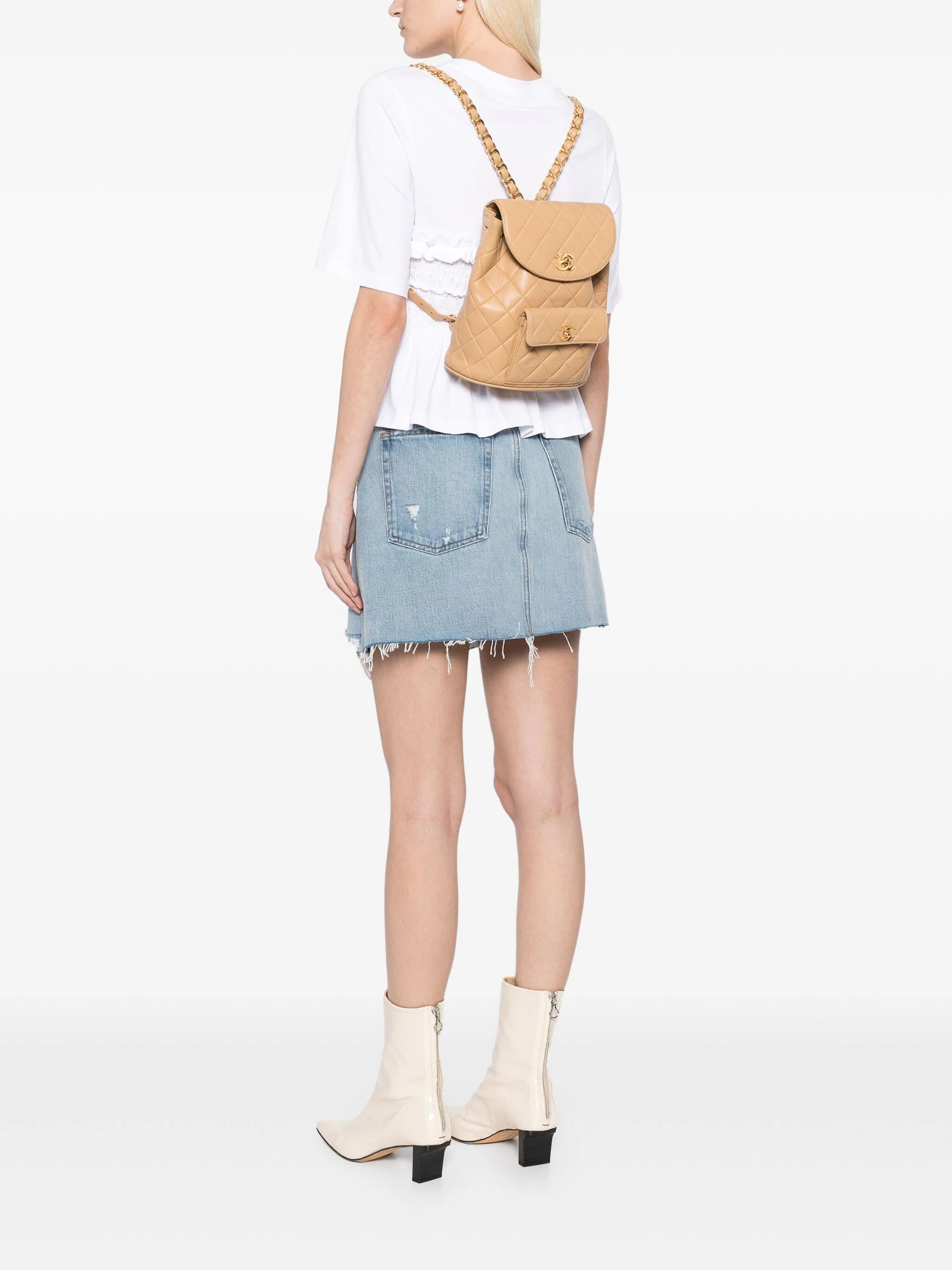 Chanel 1990's Vintage gesteppt Lammfell Duma CC Logo Beige Lederrucksack

Goldfarbene Hardware
Beigefarbenes Lammfell mit Rautensteppung
Charakteristischer CC-Drehverschluss mit Verriegelung
Zwei Schulterriemen aus Leder und