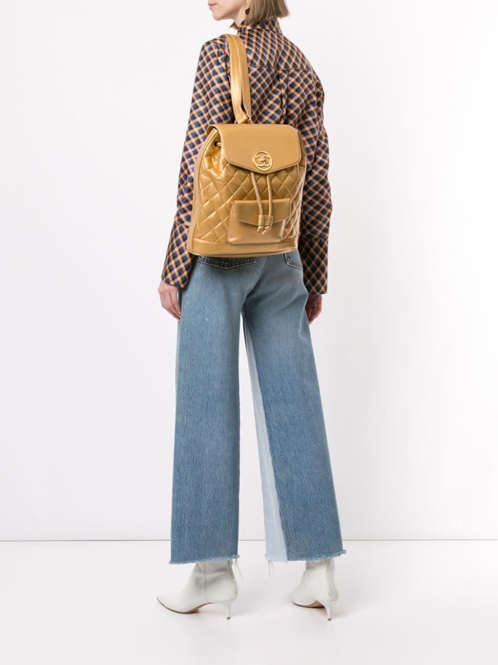 Vers 1991-1994. Ce sac à dos vintage Chanel en cuir matelassé est doté d'une quincaillerie de couleur dorée, d'une double sangle en cuir et en chaîne entrelacée, d'une poche frontale plaquée, d'un rabat frontal avec une fermeture à bouton tournant