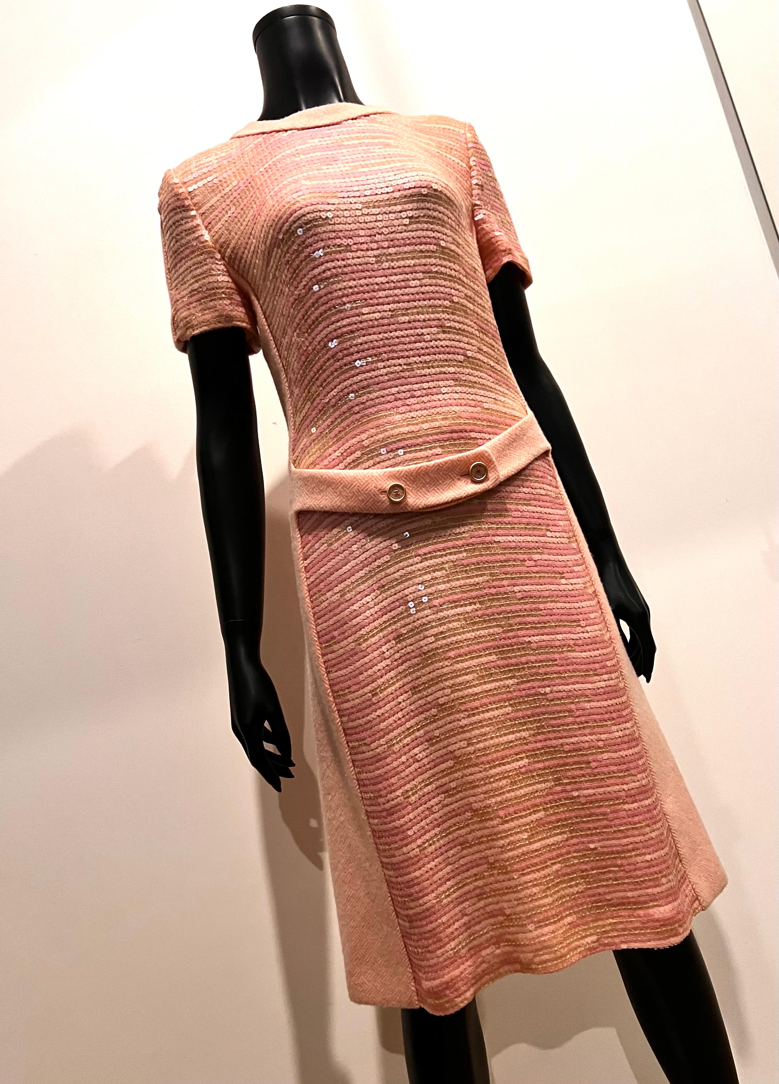 This is a piece of Chanel that you will wear & wear again as it’s the perfect dress for when you don’t know what to wear.

Crafted in wool/silk herringbone style patterned fabric in white and pink in the back to the stunning sequin front panel it