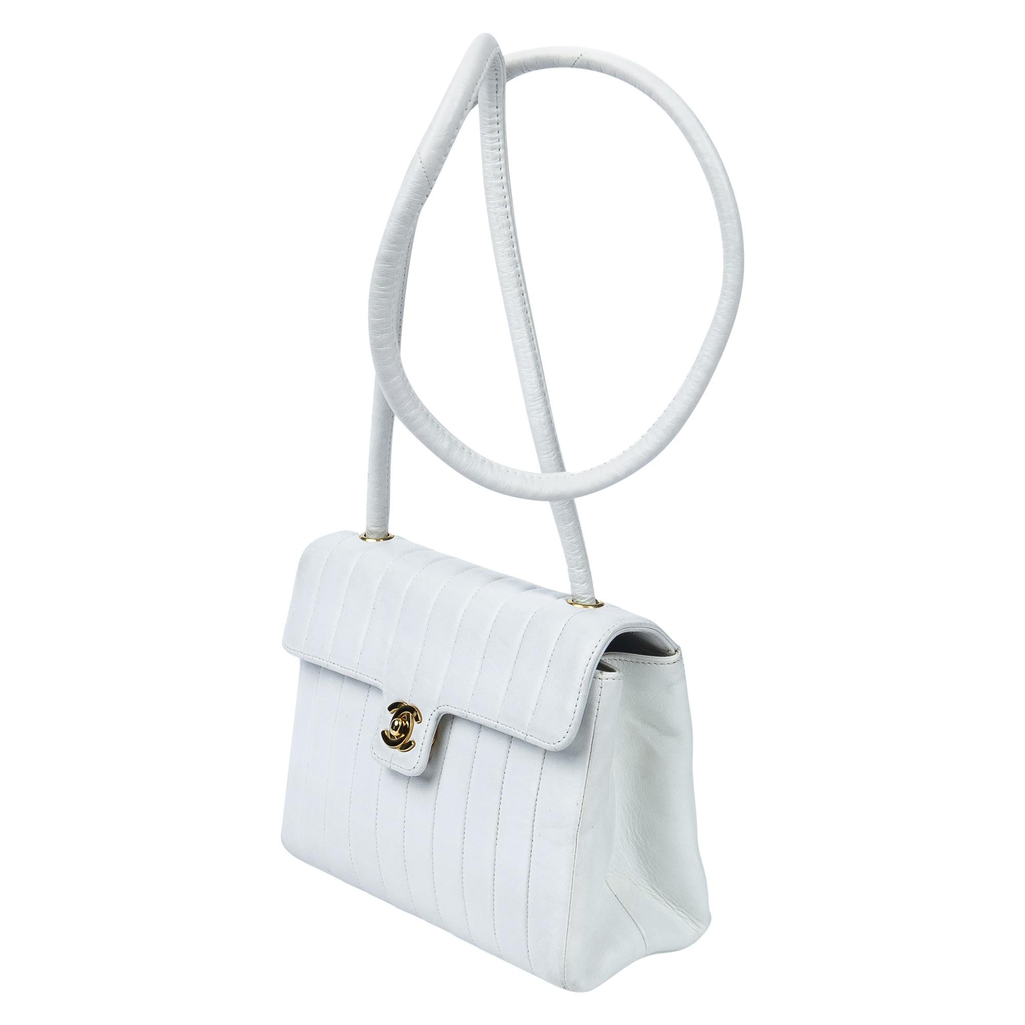 Indulge in timeless elegance with the Chanel 1991 White Striated CC Turnlock Flap Bag. Crafted from luxurious lambskin leather in pristine white, it epitomizes sophistication. Adorned with a signature CC turnlock closure in gold, its leather-lined