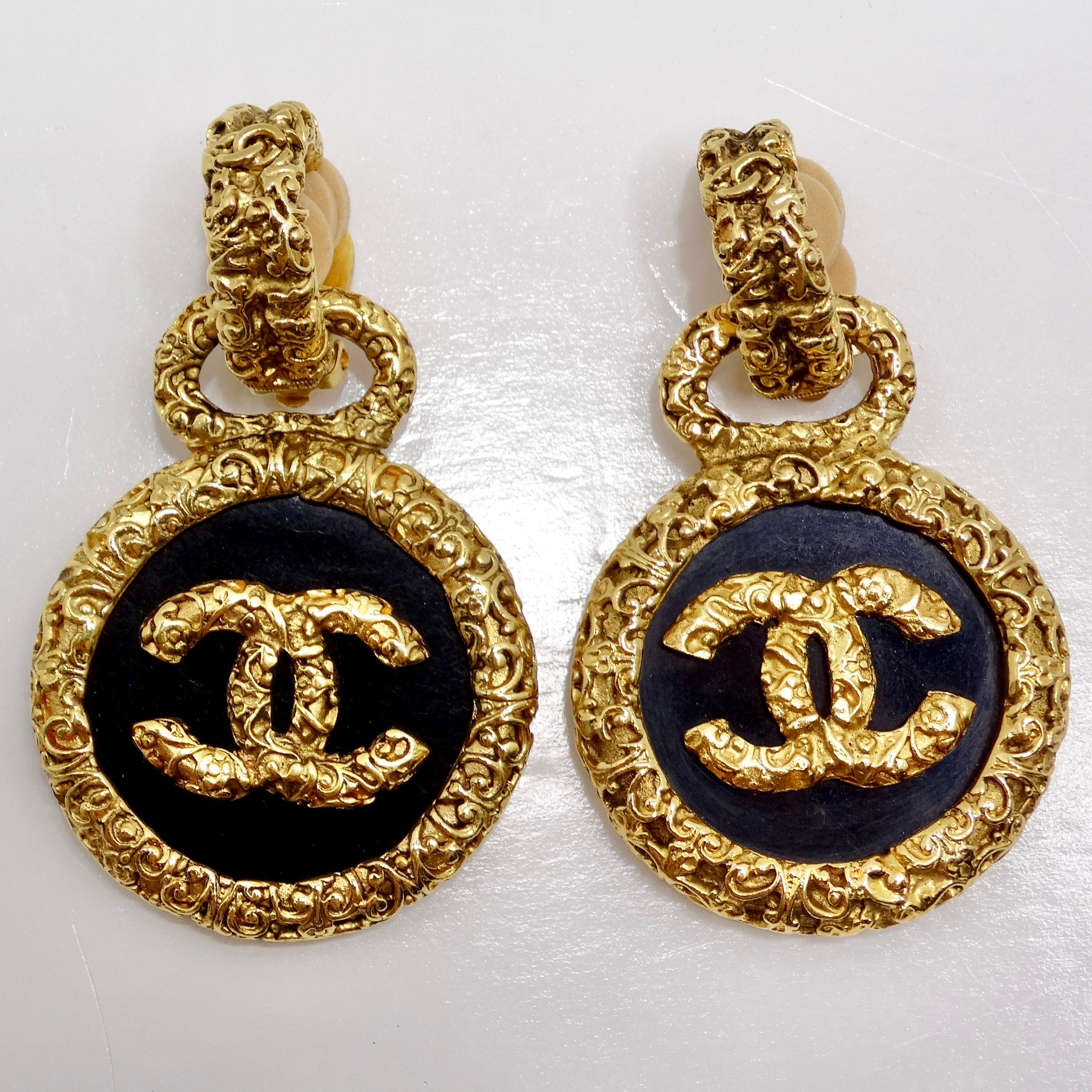 Wir stellen die exquisiten Chanel 1993 Gold Tone Black CC Medallion Florentine Ohrringe vor, ein umwerfendes Paar, das zeitlose Eleganz und Raffinesse ausstrahlt. Diese mit viel Liebe zum Detail gefertigten Ohrringe werten mit ihrem einzigartigen