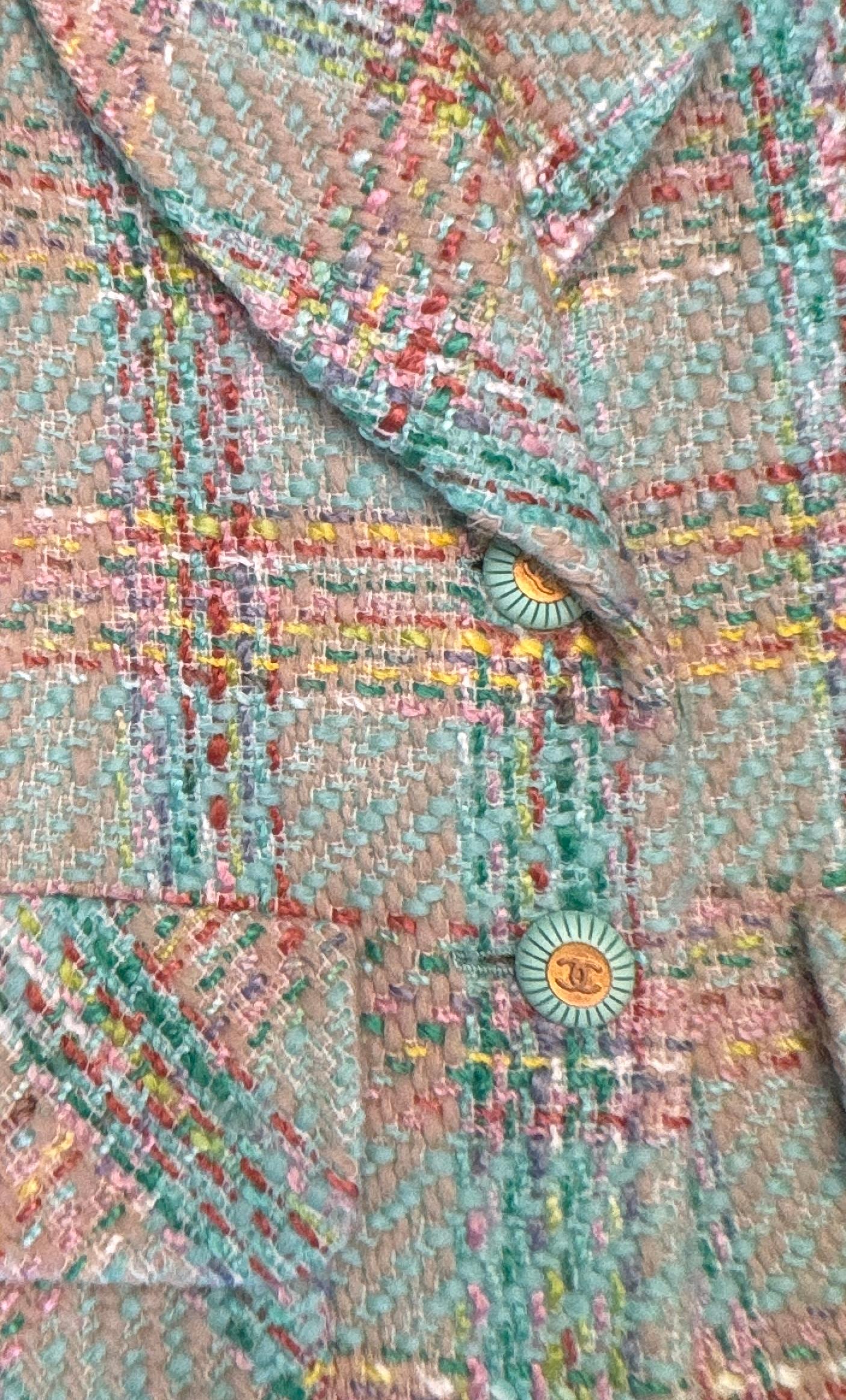 Este blazer, una extraordinaria prenda de la pasarela Chanel Primavera 1993 diseñada por Karl Lagerfeld, encarna el espíritu refinado y a la vez juguetón de Chanel de principios de los 90. Confeccionada en un característico tweed pastel, la paleta