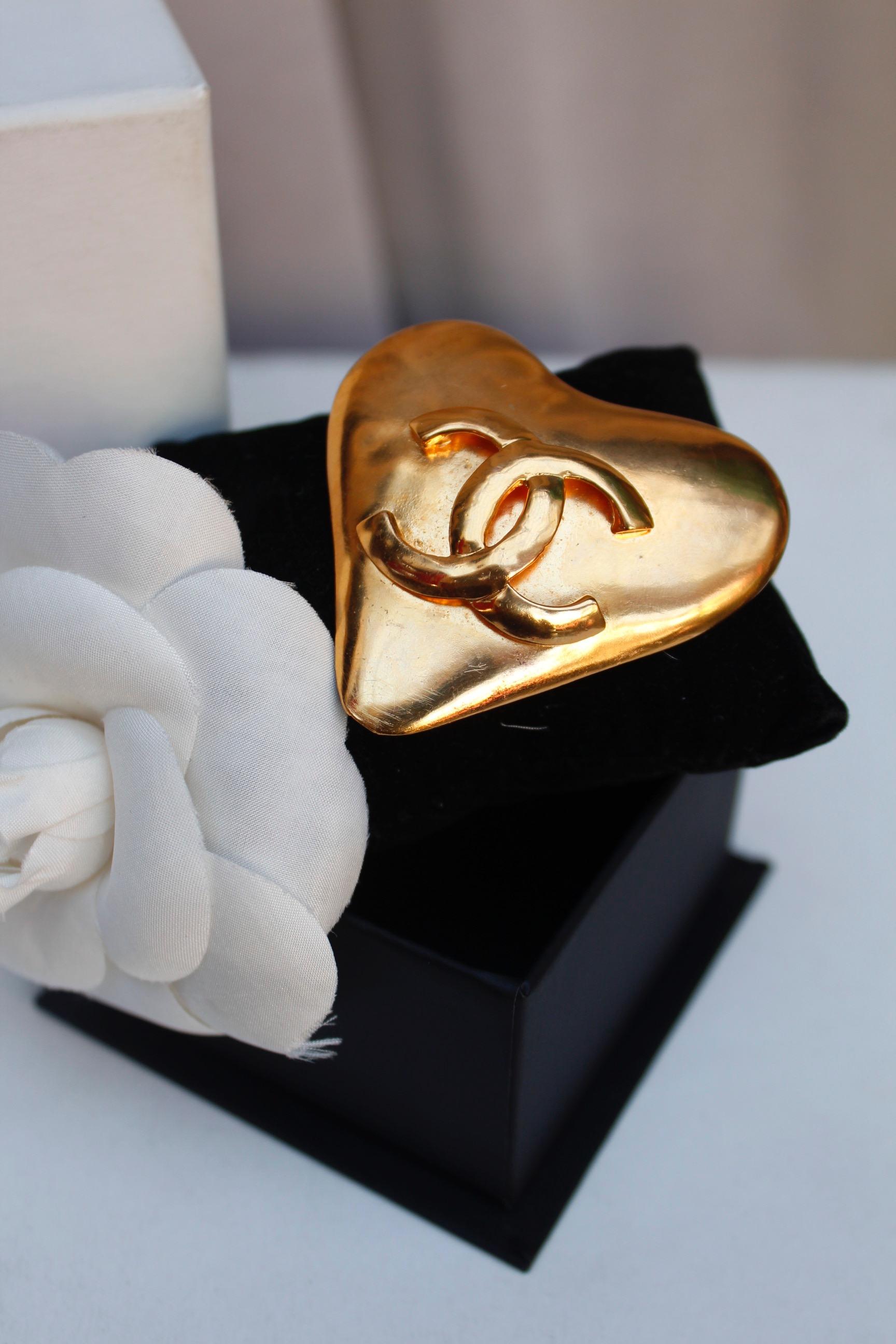 CHANEL (Made in France)
Lovely gilted metal heart shaped brooch adorned with a quite big CC logo. So 90's and easy to wear!

Spring Summer 1993 Collection

Measurements 5.5 cm x 5.5 cm (1.9 in x 1.9 in)

Very good condition

