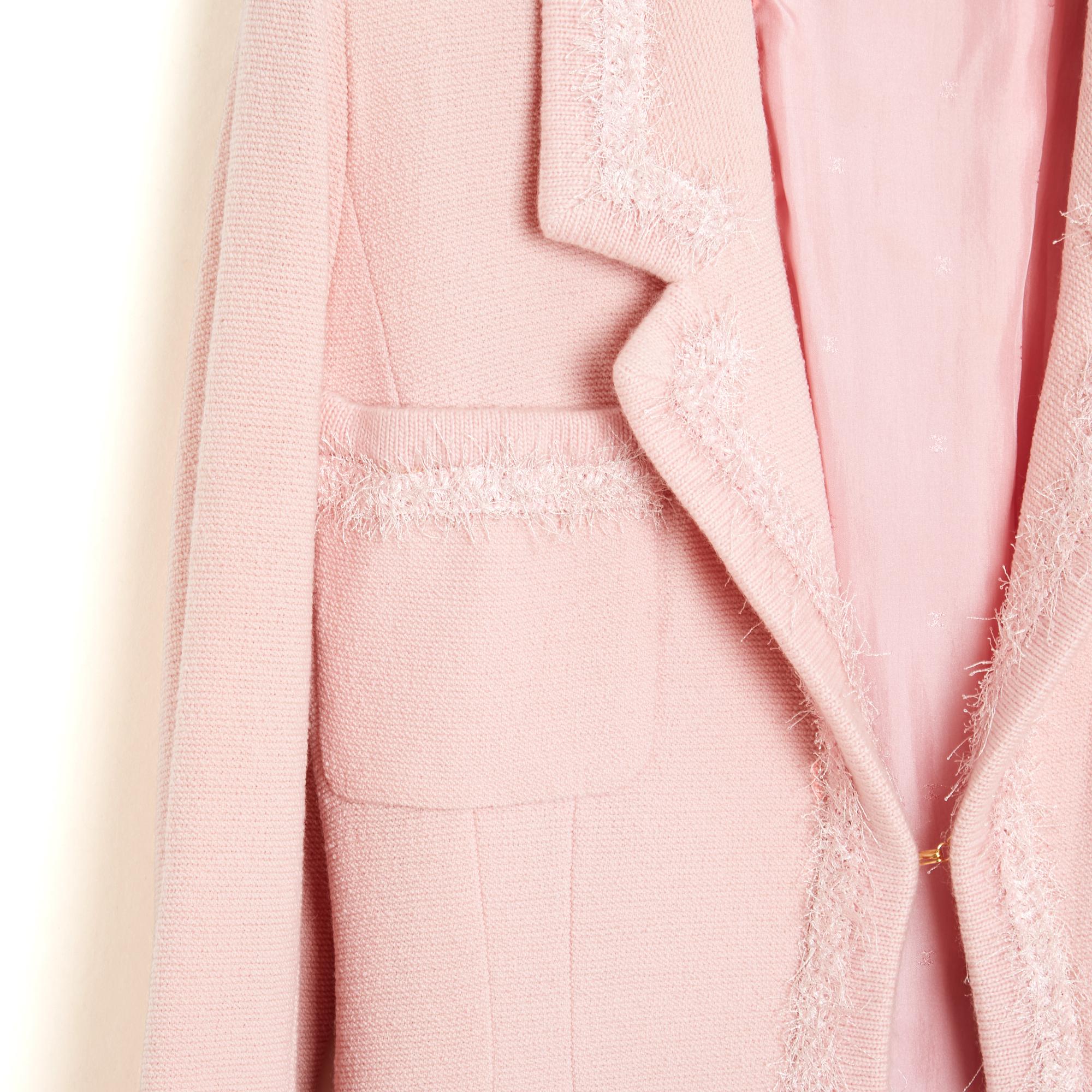 Veste Chanel de la collection AH1994 de Karl Lagerfeld en tweed de laine rose bordé d'un liseré effiloché assorti, col cranté fermé par un seul crochet, 4 poches plaquées, manches longues fermées par 3 boutons en résine rose et logo CC doré,