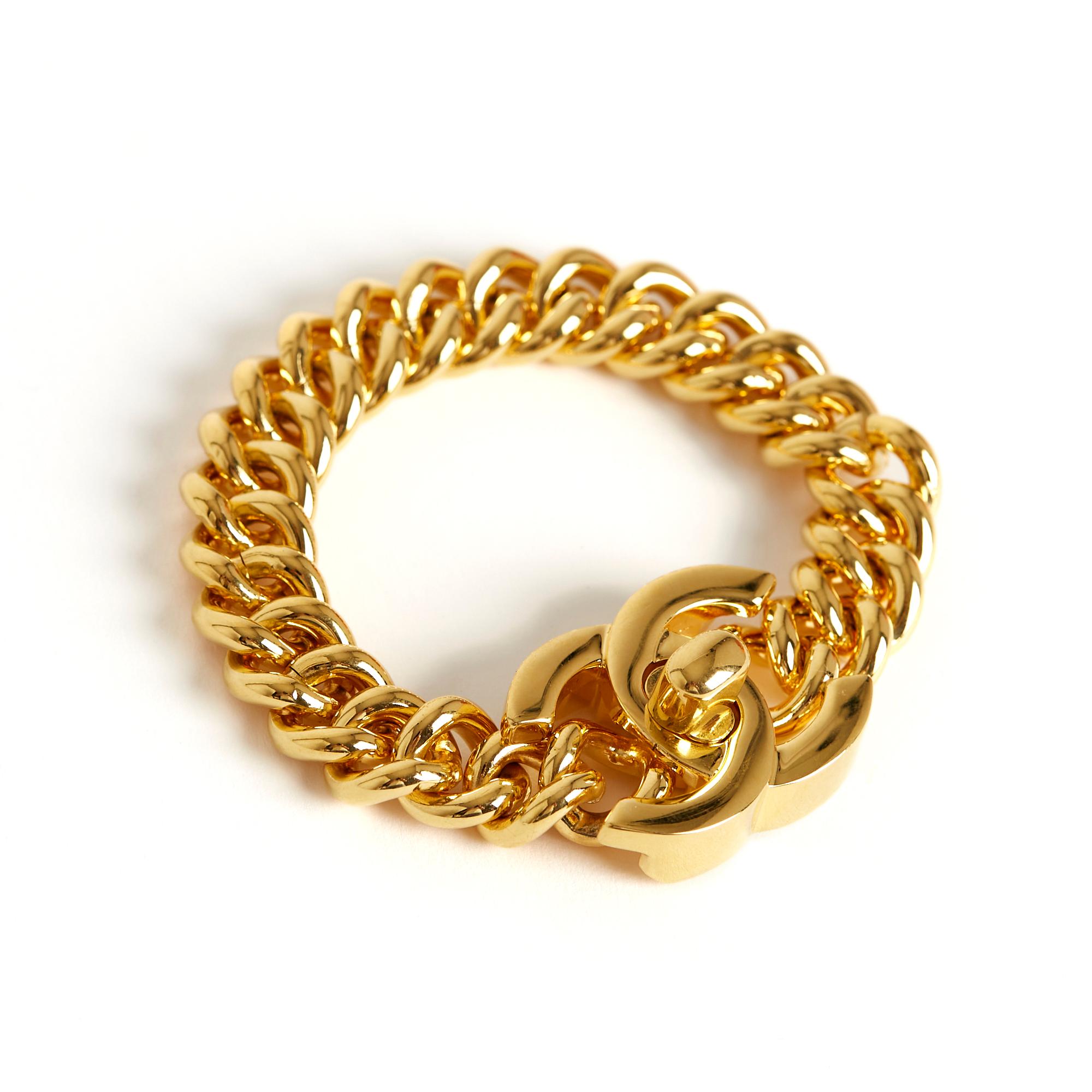 Chanel Turnlock or CC bracelet in gold-tone metal, featuring a wide curb chain and the iconic CC-shaped quarter-turn clasp from the Chanel Timeless Classique bag. Length (closed): 19 cm, chain width: 1.25 cm, clasp dimensions: 3.25 x 2.5 cm. This