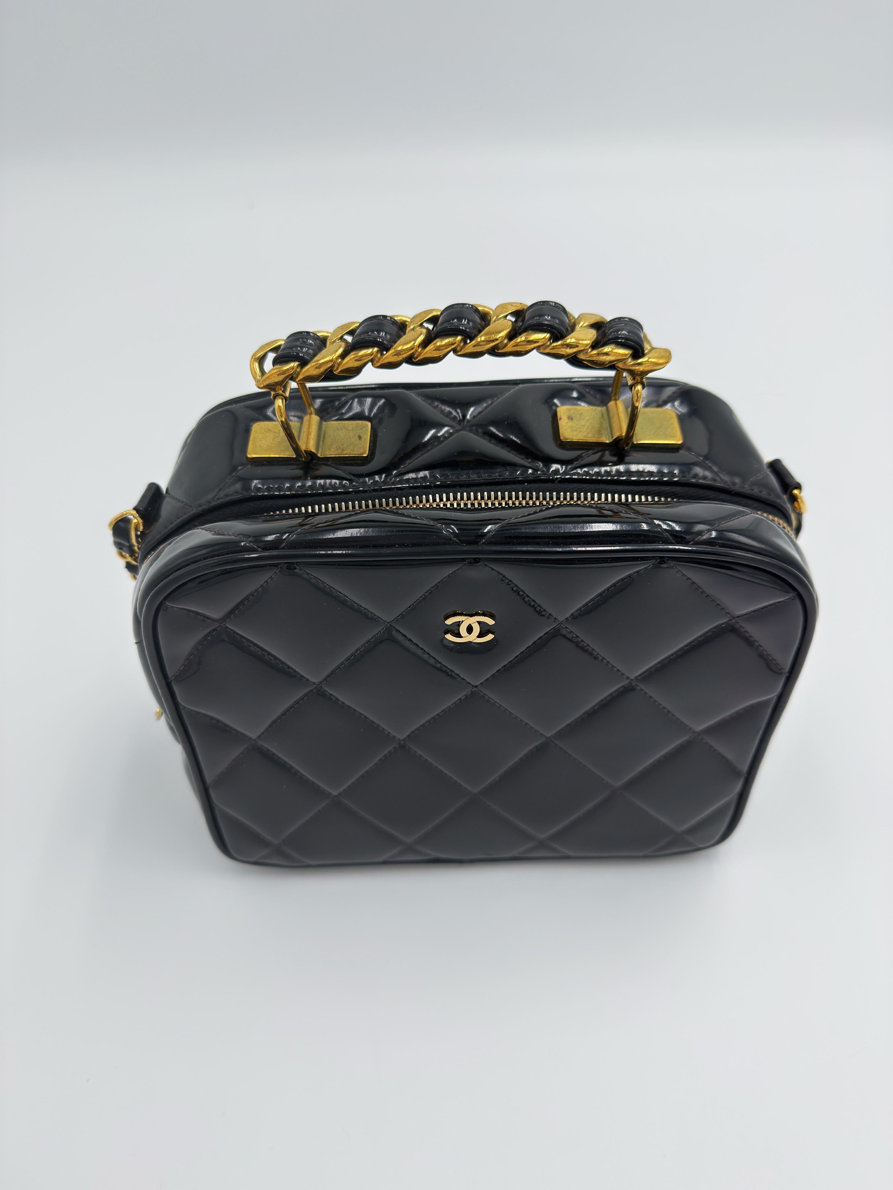 Sac de toilette Chanel 1995 ultra-rare, en cuir verni noir brillant, orné de ferrures en métal doré. Contrairement à la plupart des modèles de vanité de cette époque, ce modèle unique présente le logo CC emblématique sur le devant, ce qui en fait un