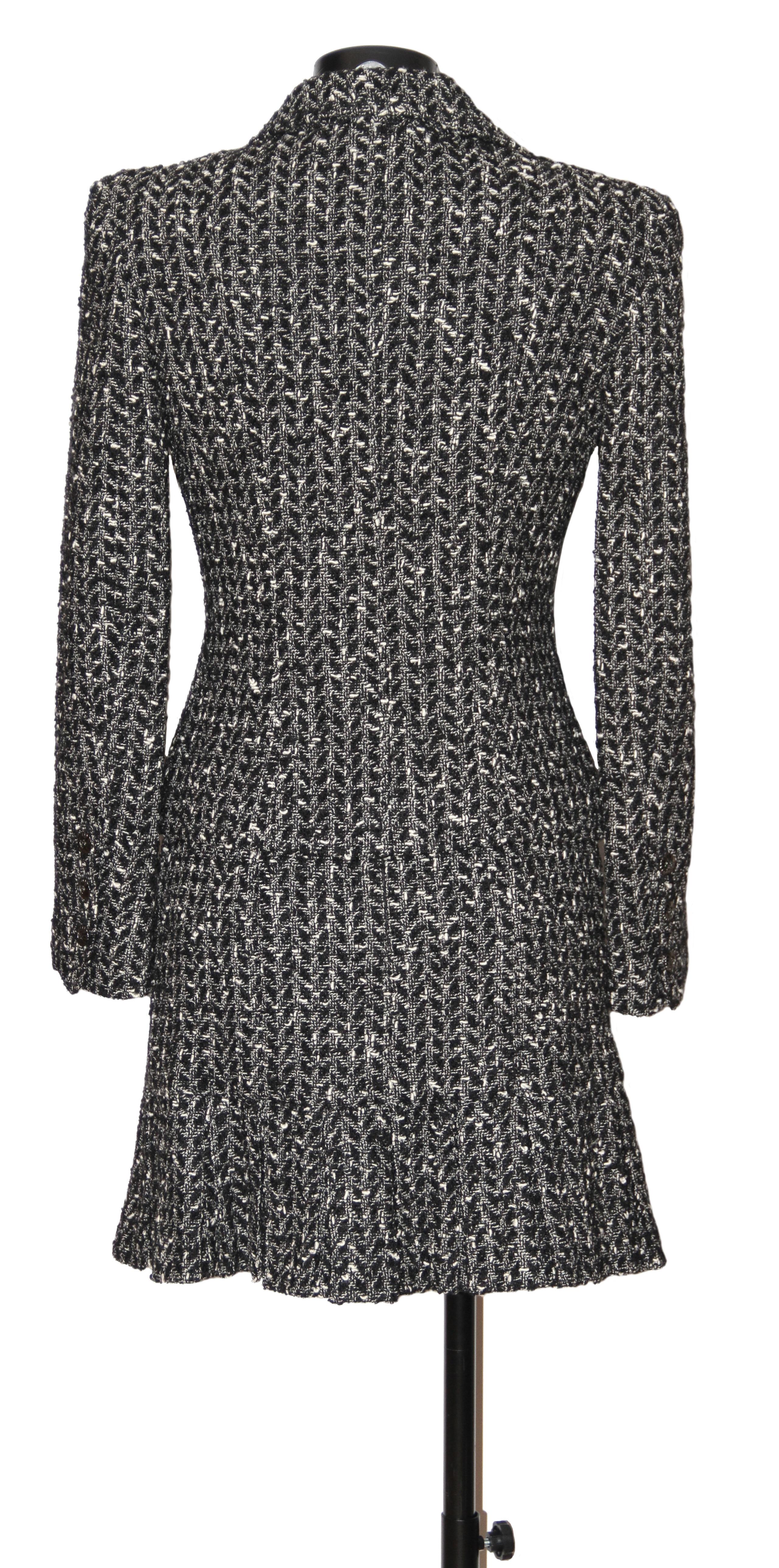 In excellent condition, this pre-owned Chanel suit is crafted in the classic black and white wool tweed. 
The jacket is single breasted finished with 4 gunmnetal CC buttons and 2 flat pockets. The sleeves have 3x small matching buttons.
The skirt