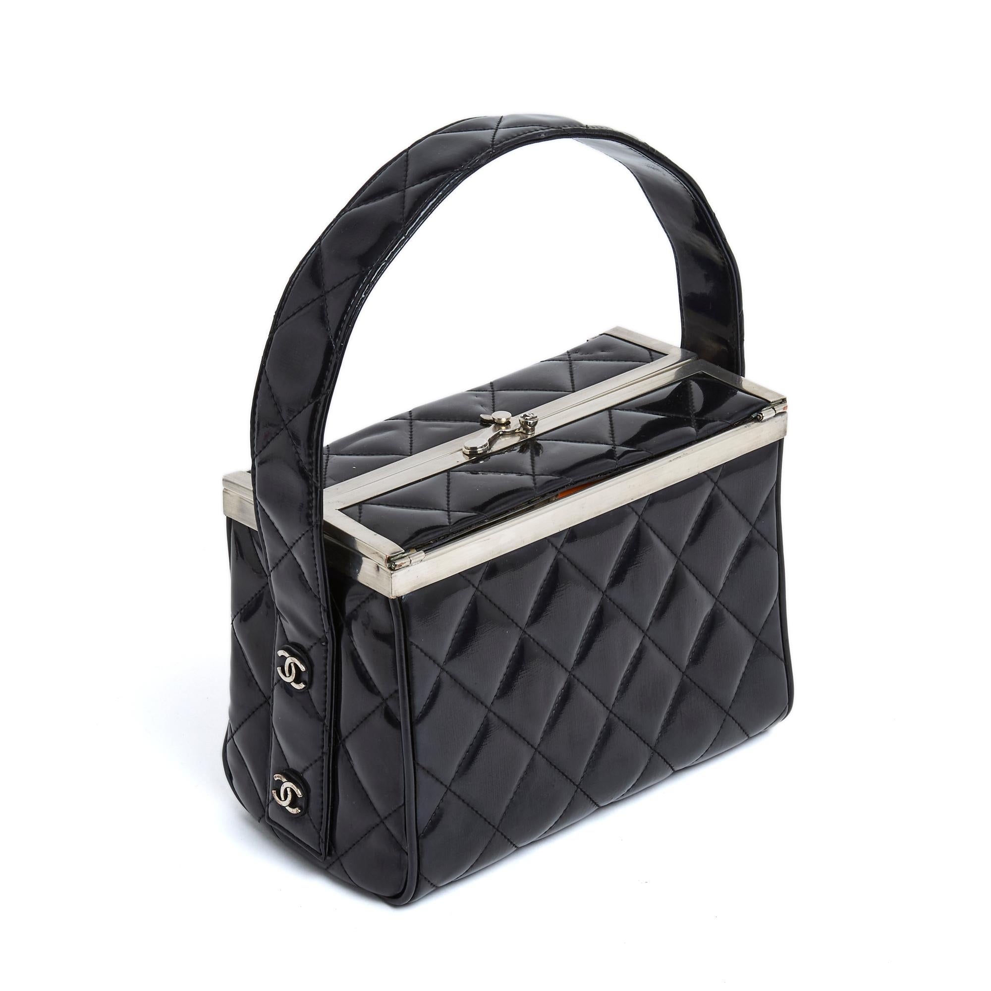 Chanel Classic series bag in quilted patent leather, box shape opened from the top with a silver metal latch with CC logo, interior with a patch pocket, wide handle for hand or shoulder carry held by CC logos on each side, year 1997. Width 19 cm x