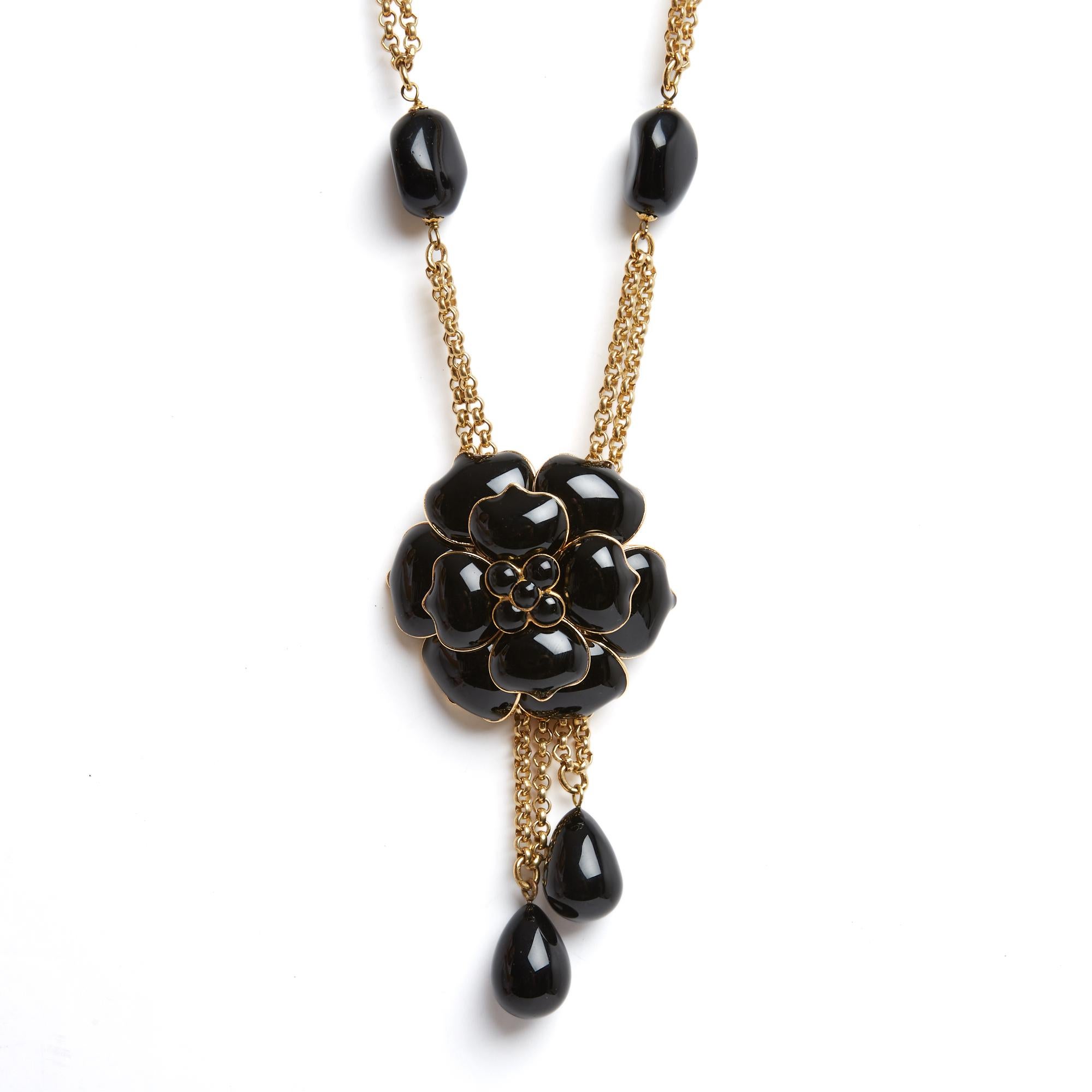 Collana o cintura Chanel sautoir del 1998 di Gripoix in metallo placcato oro decorata con una camelia e perline di vetro nero, 2 nappe mobili tenute dietro la camelia. Lunghezza totale 82 cm, diametro della camelia circa 6 cm. Il sautoir è in