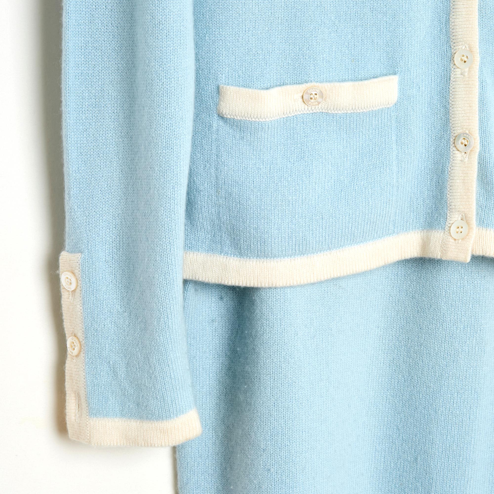 Chanel Cruise collection 1998 (?) set by Karl Lagerfeld composed of 3 pieces in sky blue cashmere knit edged with ecru including: a short-sleeved top or sweater, round neck closed with a CC logo button on the back, a cardigan with long sleeves