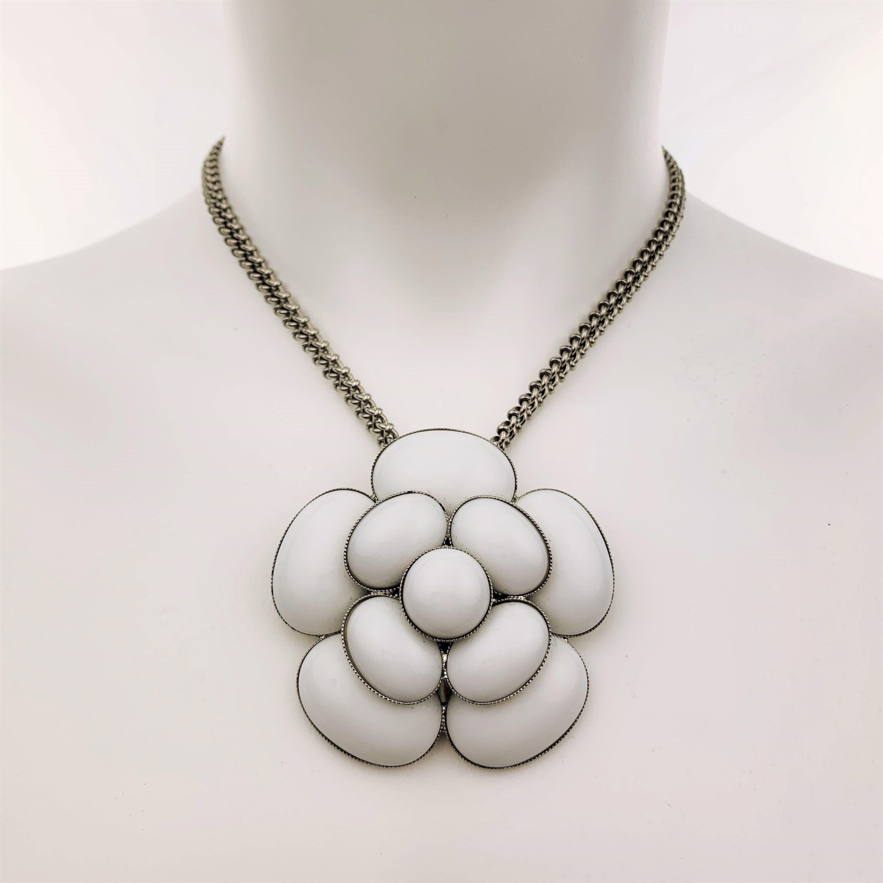 Vintage CHANEL circa 1998 necklace features a 3D white enamel Camellia floral pendant on an adjustable silver tone metal chain with CC logo charm. Made in France.
 
Excellent Pre-Owned Condition.
Marked: 98 C
 
Chain: 18 in.
Pendant: 6 x 6 cm.