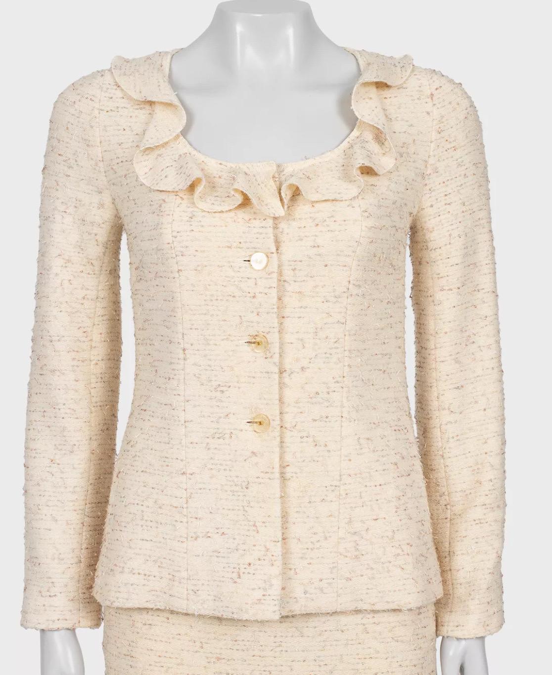 Entrez dans l'élégance intemporelle avec cet exquis tailleur en tweed ivoire de Mary Quant's Chanel by Karl Lagerfeld, issu de la collection Automne-Hiver 1999-2000. Ce costume deux pièces raffiné est confectionné en laine fine, offrant une