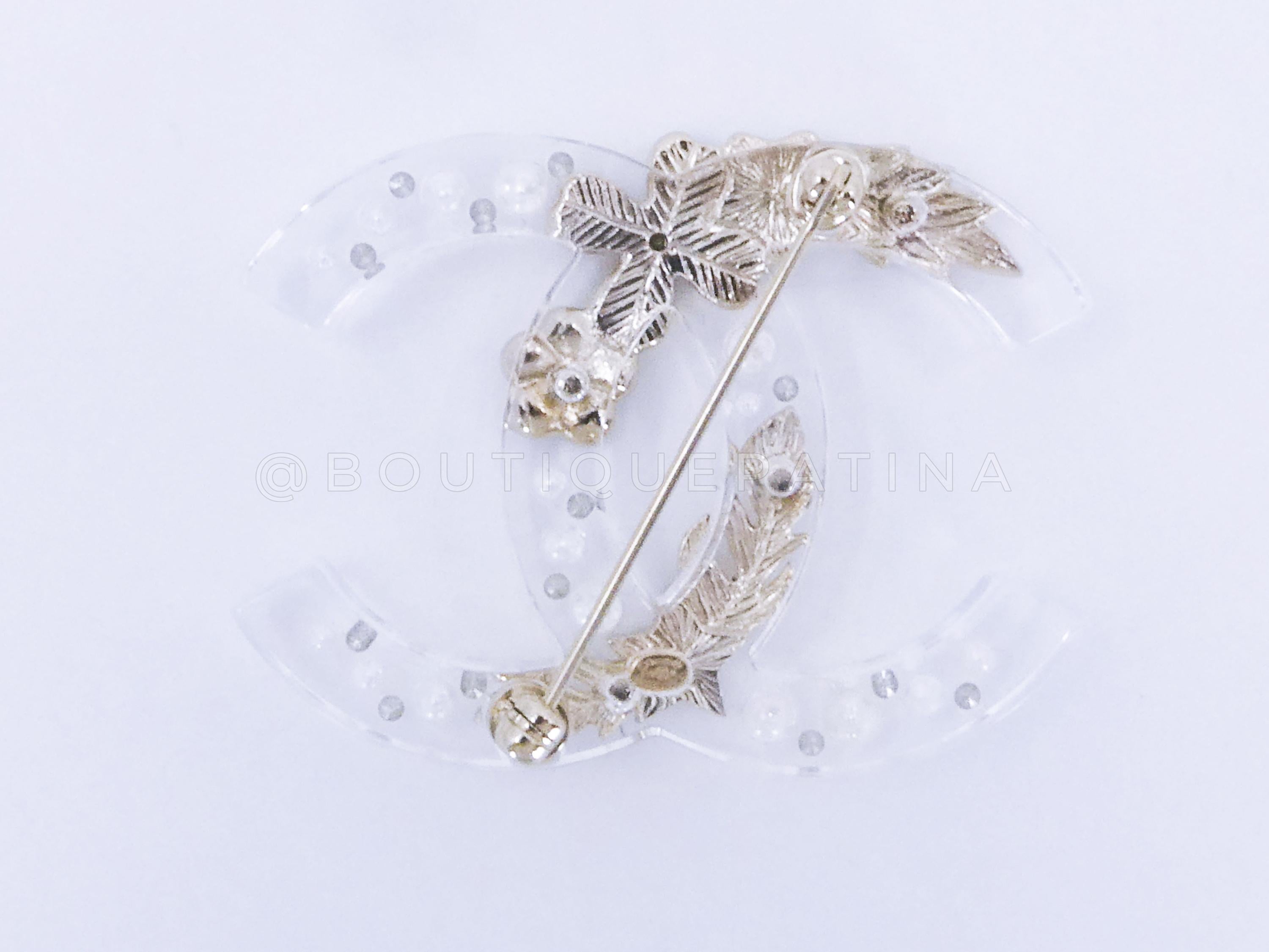Store item: 66079
Chanel 19K Clear Acrylic Lucite CC Ornament Brooch 
Stamped 19K for 2019 Fall/Winter

White clear acrylic embedded with brushed gold, faux pearl and crystal ornaments

Condition: Excellent
For 19 years, Boutique Patina has