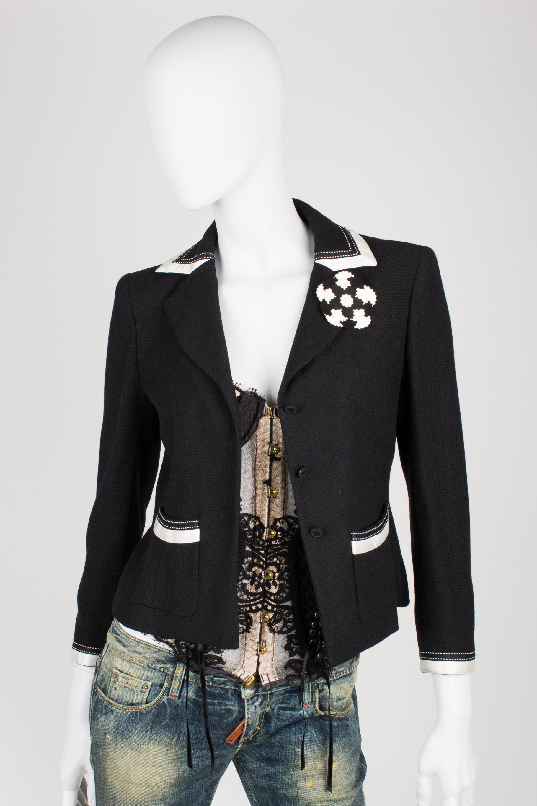 Beautiful black and white Chanel suit; a blazer and a skirt

The blazer is made of black fabric with white satin trimming. Black coin buttons at the front, three in a row. At the end of the sleeves also three of these buttons, a little bit smaller