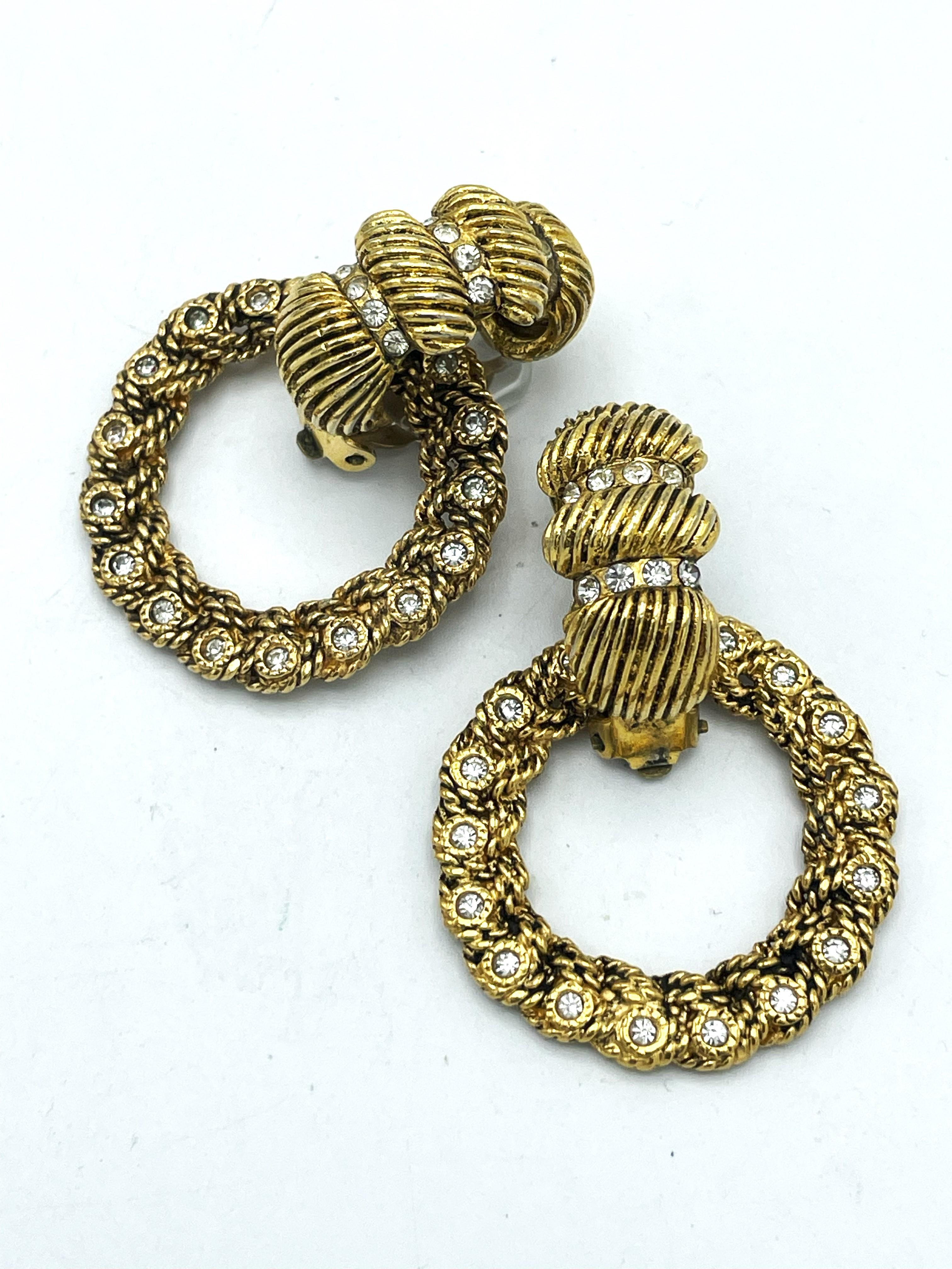 2 piece CHANEL Clip-on earring ( Made in France), singed 1970/80's 
A decorated hoop earrings hangs in the upper clip part. Both parts are decorated with small rhinestones.

Dimensions:
Hight   5, 5 cm 
With     3, 8 cm 
Hoop   3,8 cm in Diameterand