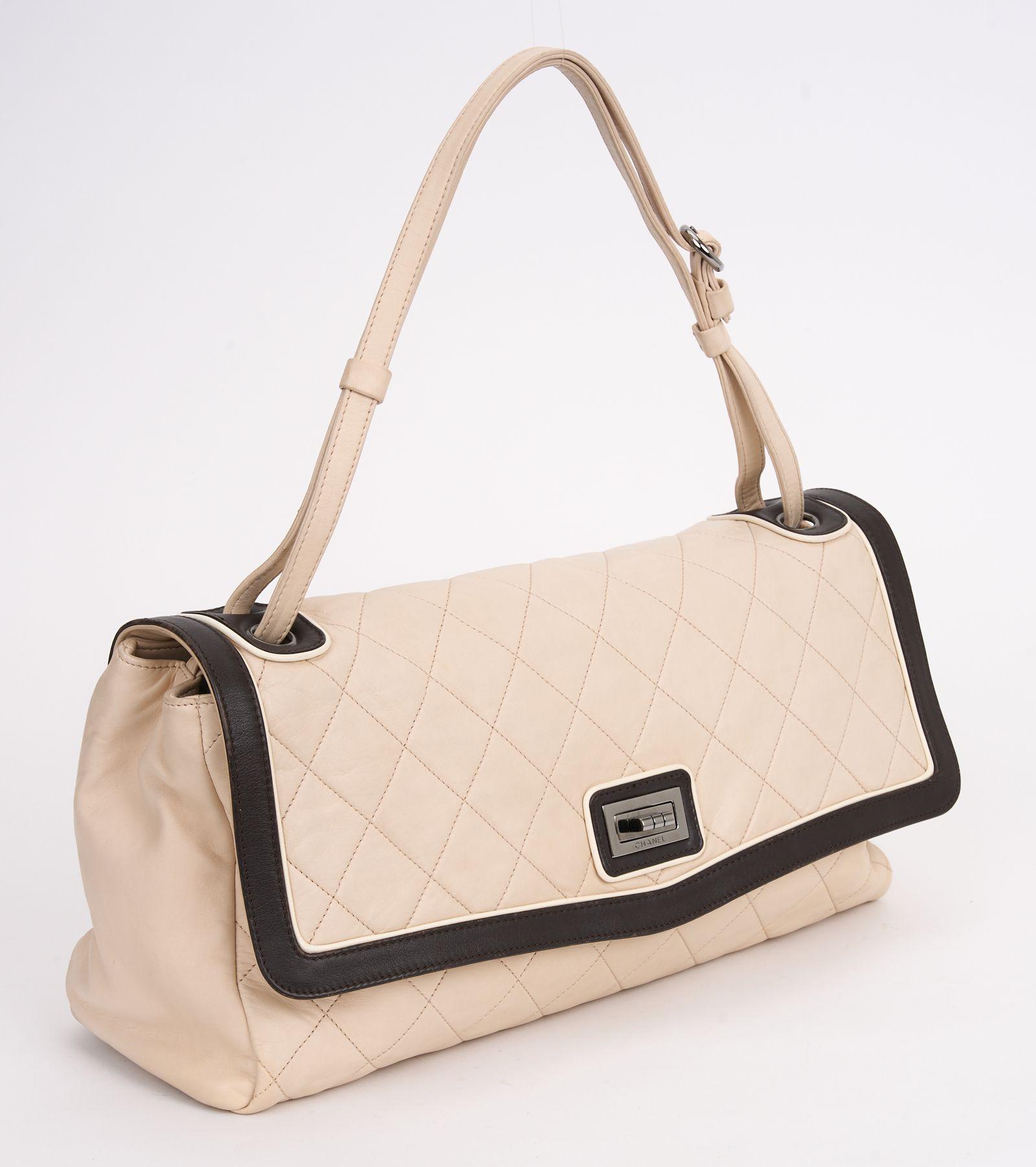 This Chanel 2 tone Lambskin Shoulder Bag from the collection by Karl Lagerfeld, features
a neutral lambskin, gunmetal hardware, a canvas trim, a single adjustable shoulder strap,
a single exterior pocket, three interior pockets, and turn lock