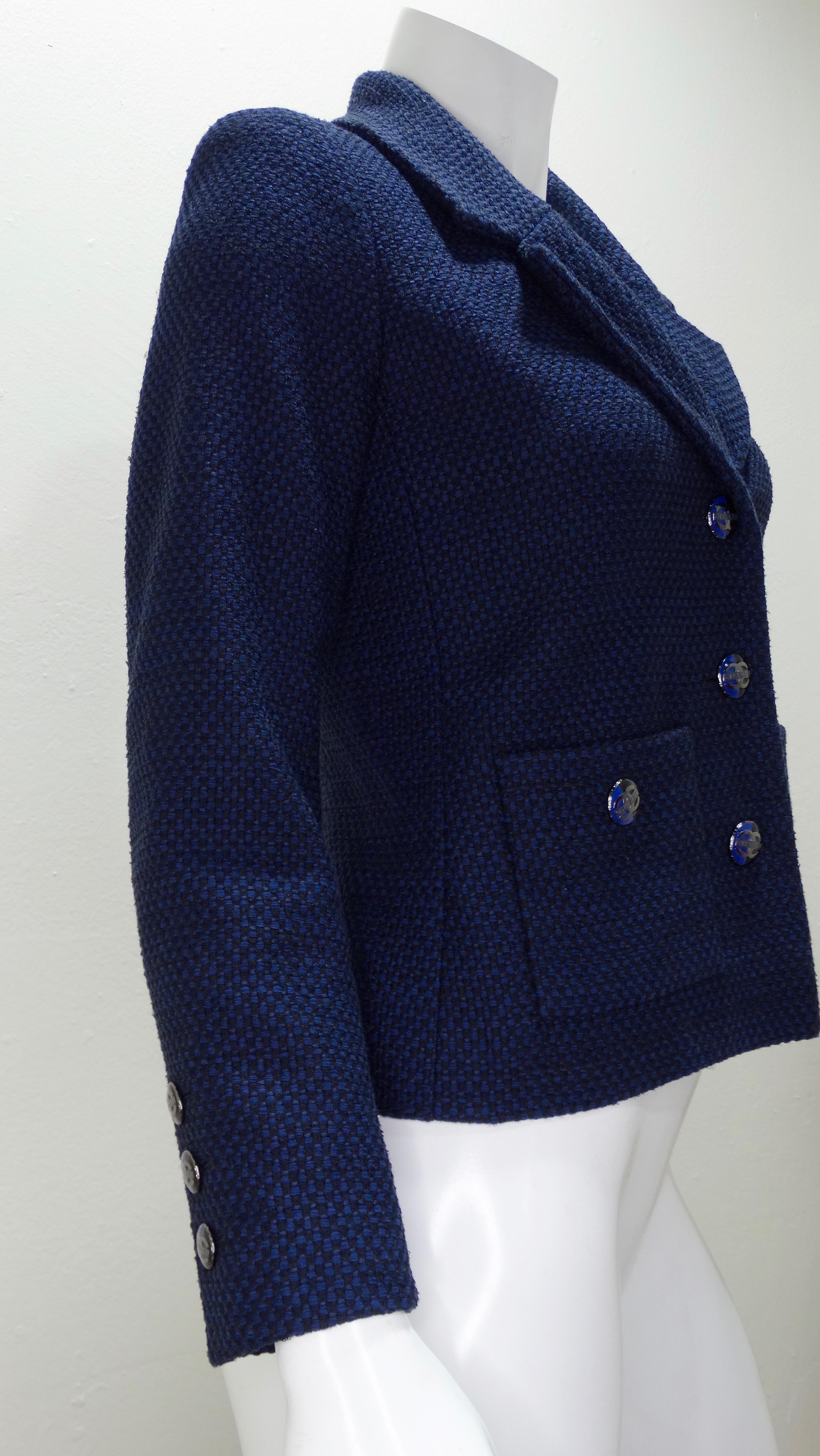 For all the Chanel lovers! Circa recent 2000s, this black and navy woven blazer features a deep v-neck with a notched collar, two front square pockets, and matching enamel CC buttons. Interior is lined with Chanel fabric. Timeless and classic, this