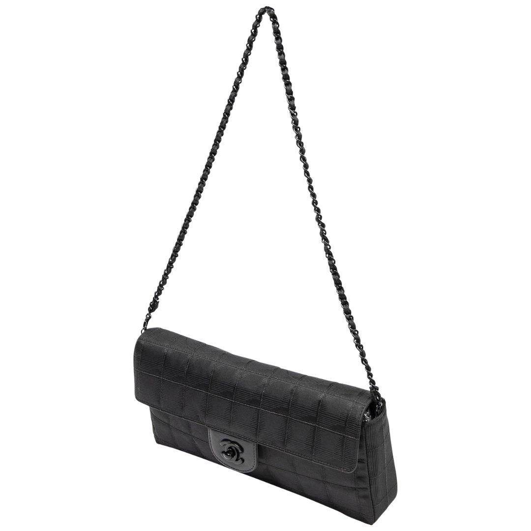 The Chanel Black Travel Ligne East West Flap Bag is the epitome of practical luxury. Crafted from durable nylon canvas, it features sleek black chrome hardware and a CC turnlock closure. The leather-lined interior boasts two pockets for effortless