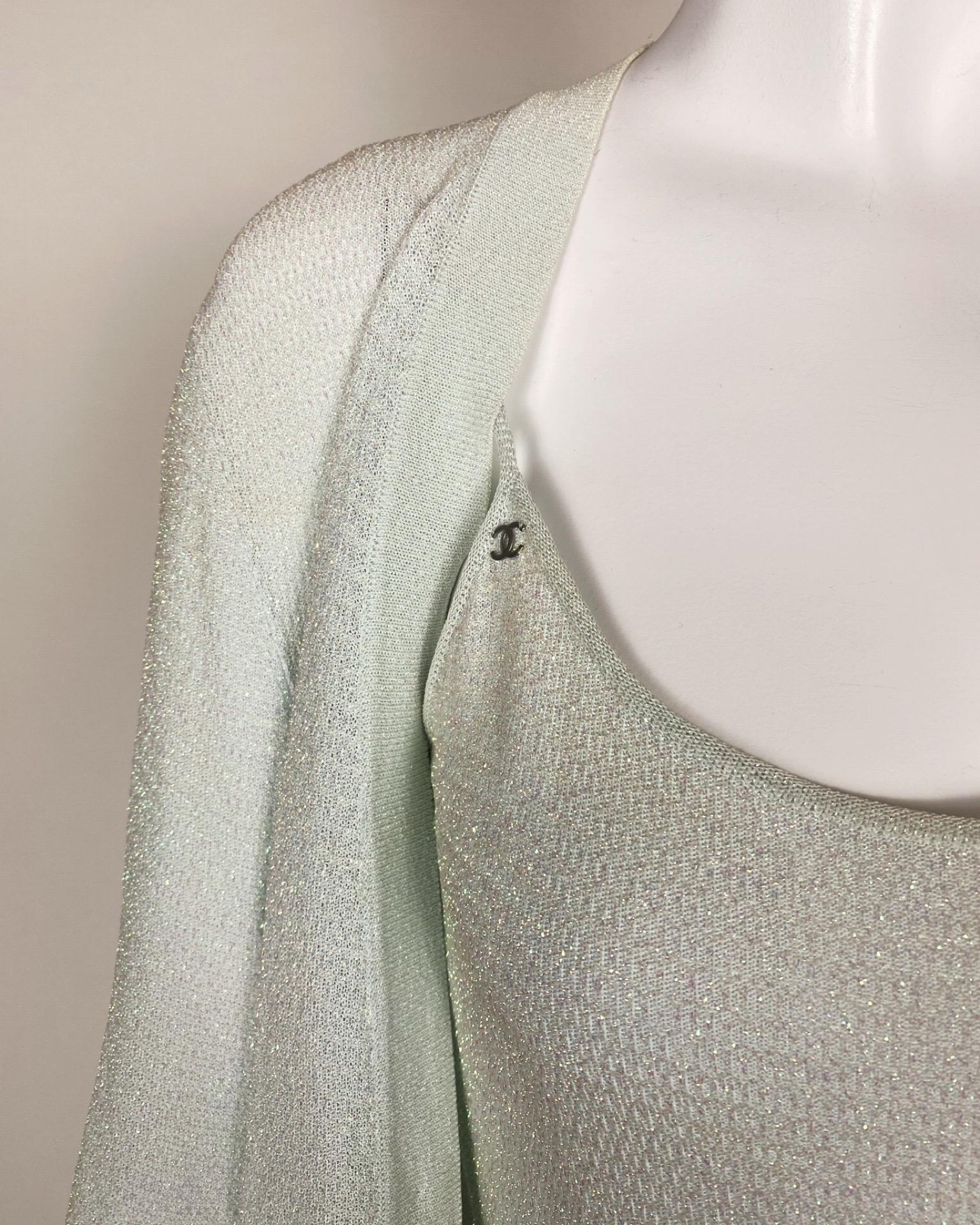Step into the fashion-forward future with this remarkable CHANEL 2000s Iridescent Mini Dress & Cardigan Set. This set includes two pieces in a striking light blue shade, showcasing a captivating iridescent knit effect that is sure to captivate all