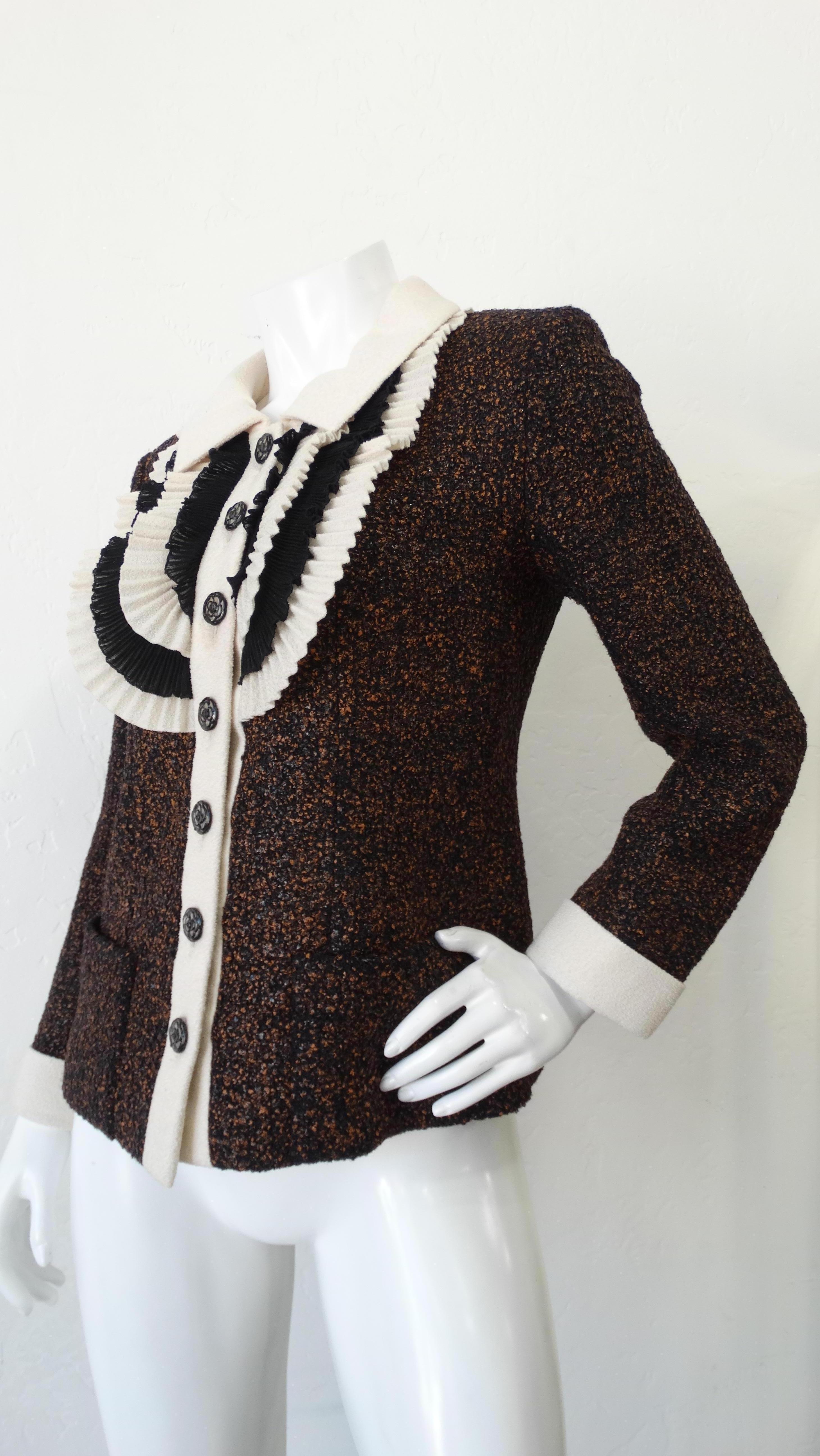 Channel your classic Chanel girl with this tweed jacket! Circa 2000s, this tweed jacket features a white terry cloth collar, cuffs and placket. Includes black and white layered pleating on the chest, Camellia flower buttons and two square front