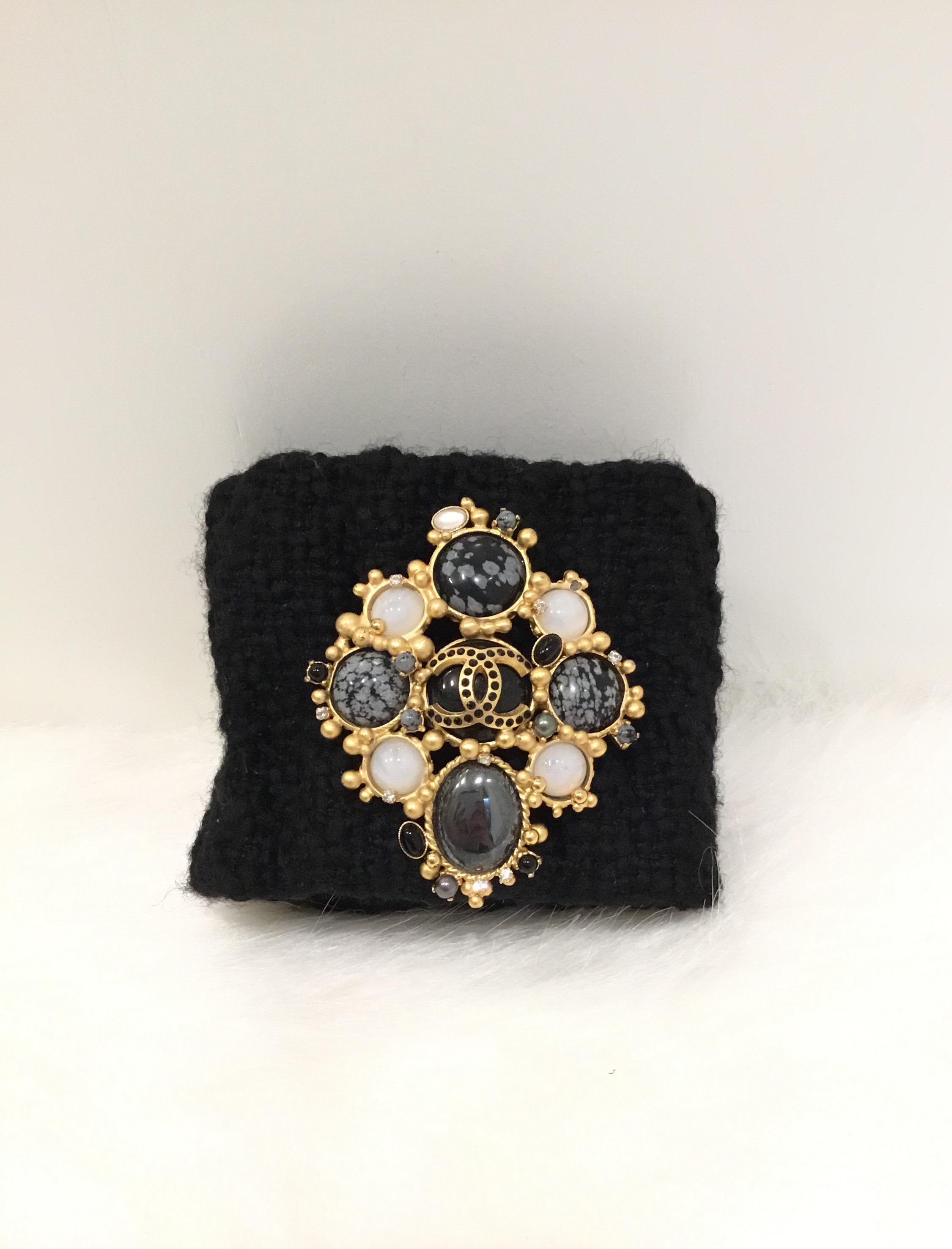 Chanel Black tweed bracelet with a removable brooch with gold-tone hardware. Bracelet has snap closures and lined in leather. 2001 A collection.

Length 8”
Width 3.5”