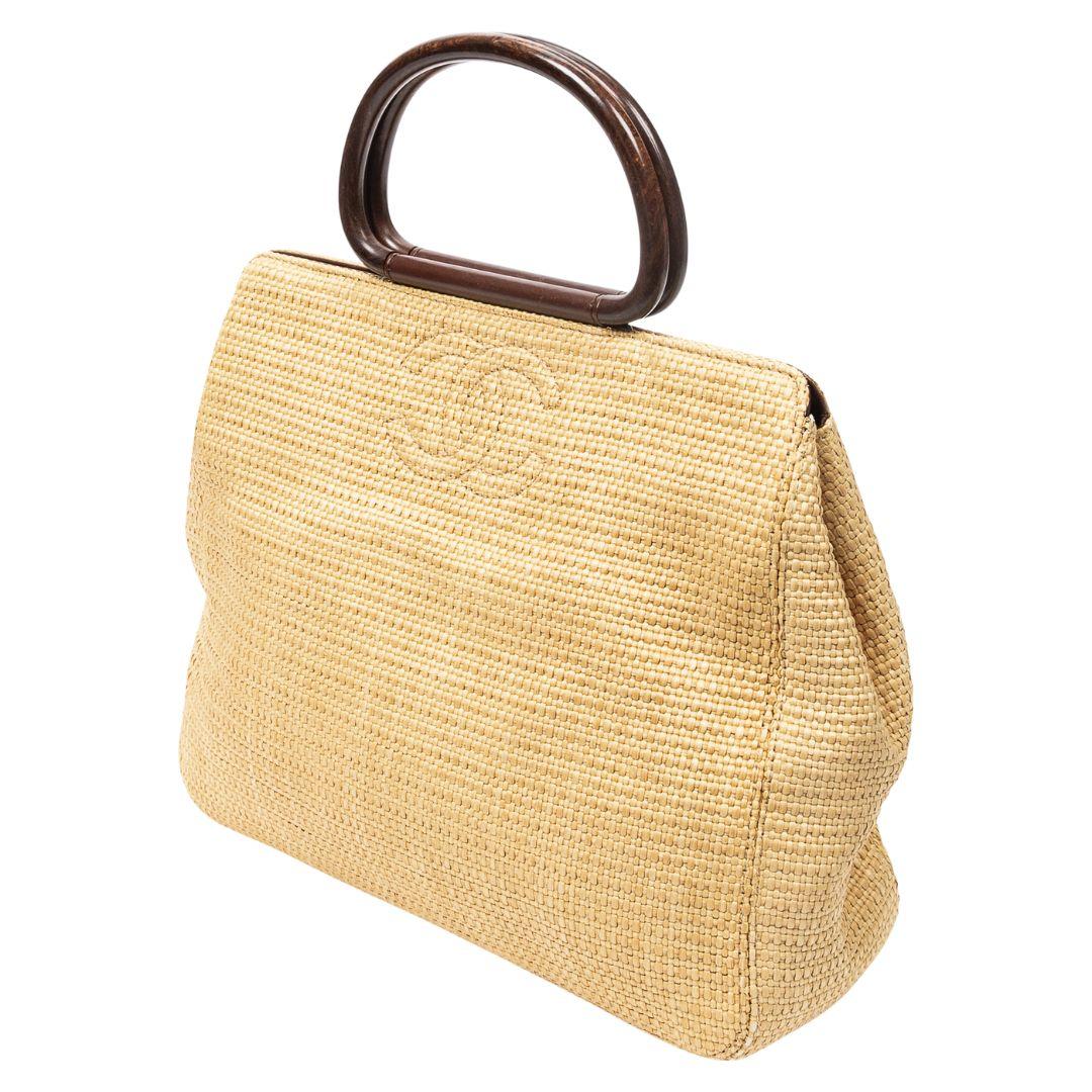 The Chanel CC Basket Bag in beige raffia with silver hardware and a magnetic snap closure is a testament to laid-back luxury. Its grosgrain-lined interior includes one zippered pocket for everyday essentials.

SPECIFICS
• Length: 12.6