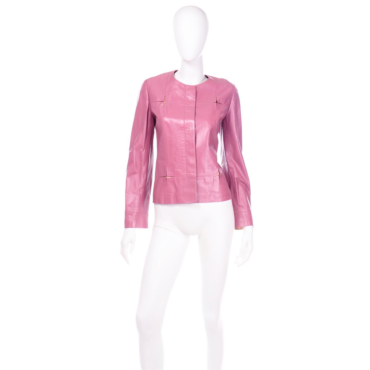 This berry pink leather Chanel jacket is in a soft lambskin leather and it has pops of rose gold in fun square star cutouts. This unique detail is found along the front of the jacket and on the cuffs of the sleeves. This jacket is collarless and has