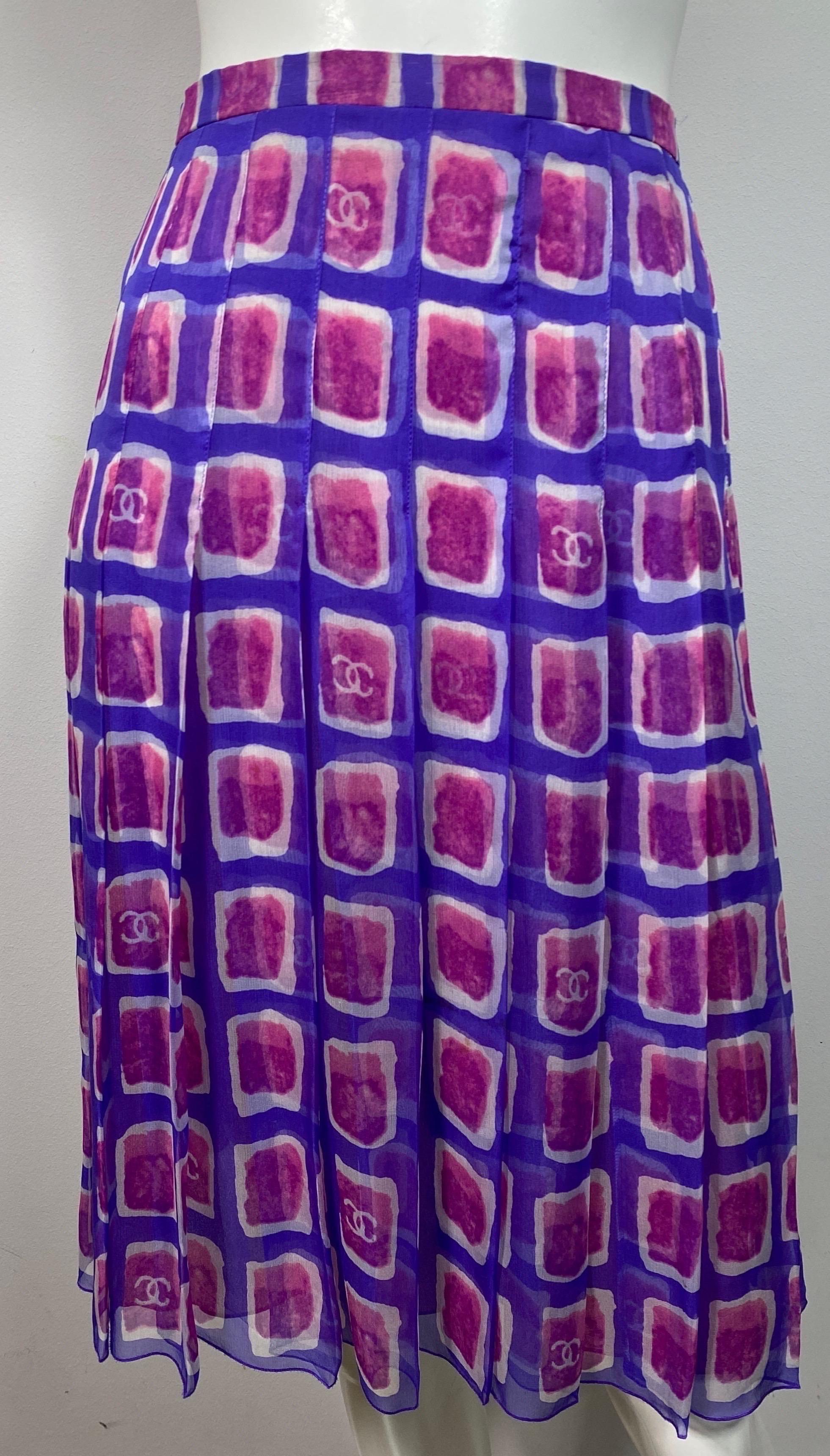 Chanel 2001 Purple and Fuchsia Silk Print Skirt - Size 40 This vintage skirt is made of a purple silk chiffon that has watercolor looking squares made of Fuchsia and Ivory, some with the CC in the center. The skirt is lined in a magenta colored