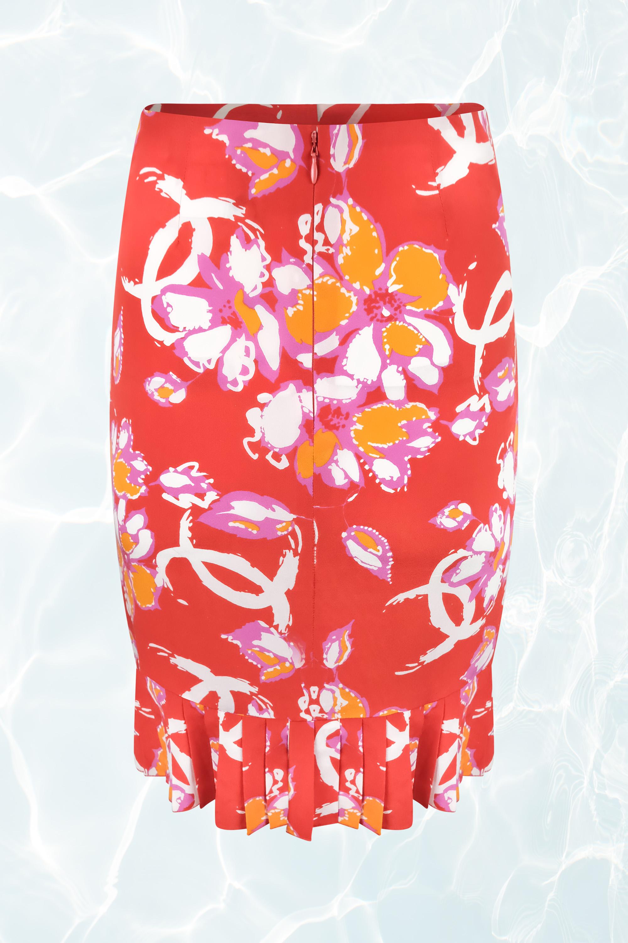 This Chanel 2001 skirt features a vibrant red base with a bold floral print accented by Chanel’s iconic interlocking 