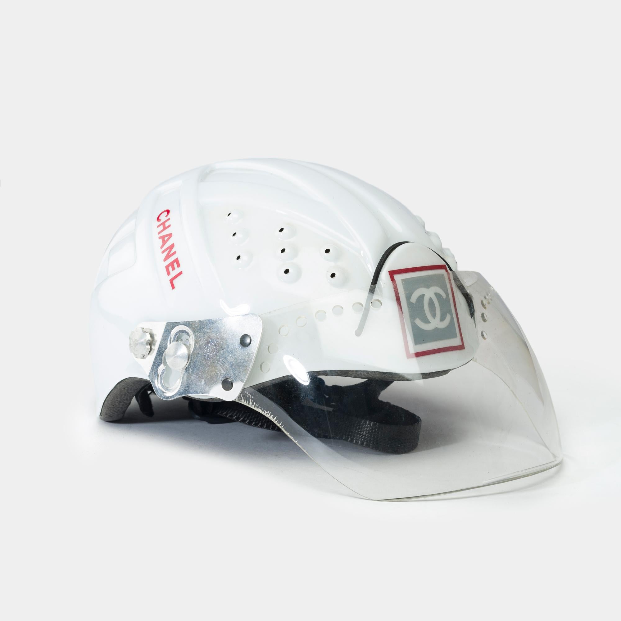 Rare​ ​Chanel​ ​mountain​ ​climbing​ ​helmet​ ​limited​ ​edition​ ​of​ ​the​ ​2001​ ​collection​ ​in​ ​white,​ ​red​ ​and​ ​black​ ​acetate,​ ​silver​ ​metal​ ​trim

CC​ ​logo​ ​nested​ ​on​ ​the​ ​front
Logo​ ​on​ ​the​ ​sides
Transparent​ ​visor​