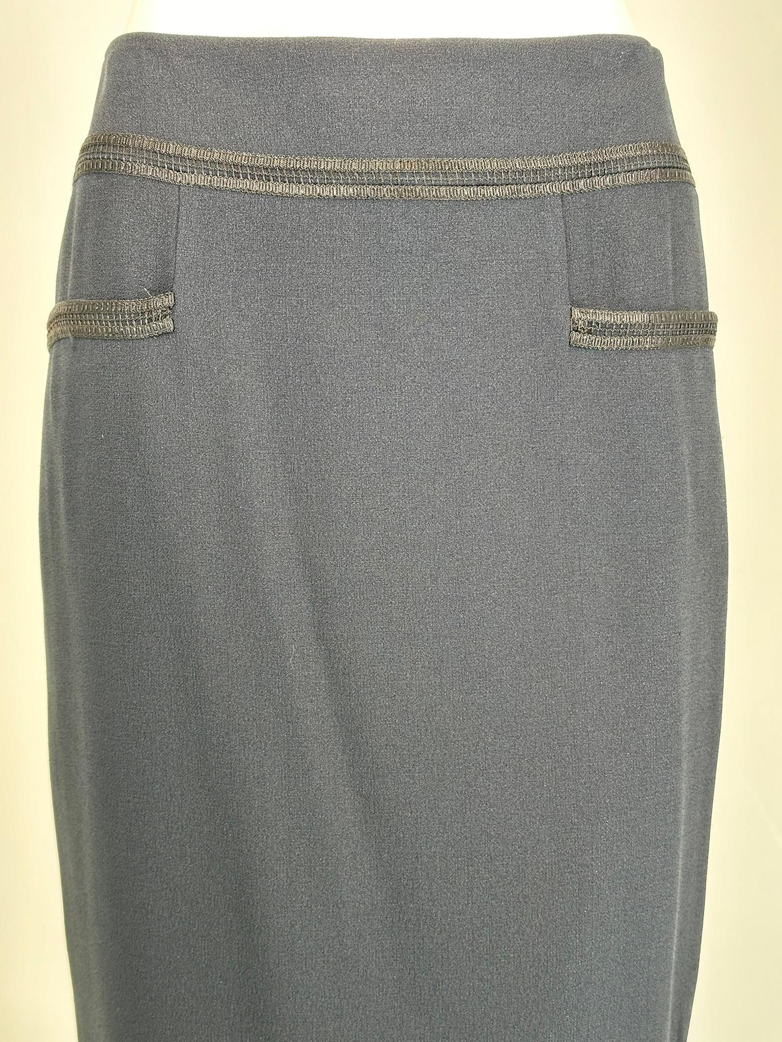 Chanel 2002C - Jupe crayon en crêpe bleu foncé avec empiècement de hanche en soutache noire et fausses poches sur le devant. Doublé de soie bleu foncé. La jupe se ferme au dos par 2 boutons en camélia de Chanel à la taille et une fermeture à