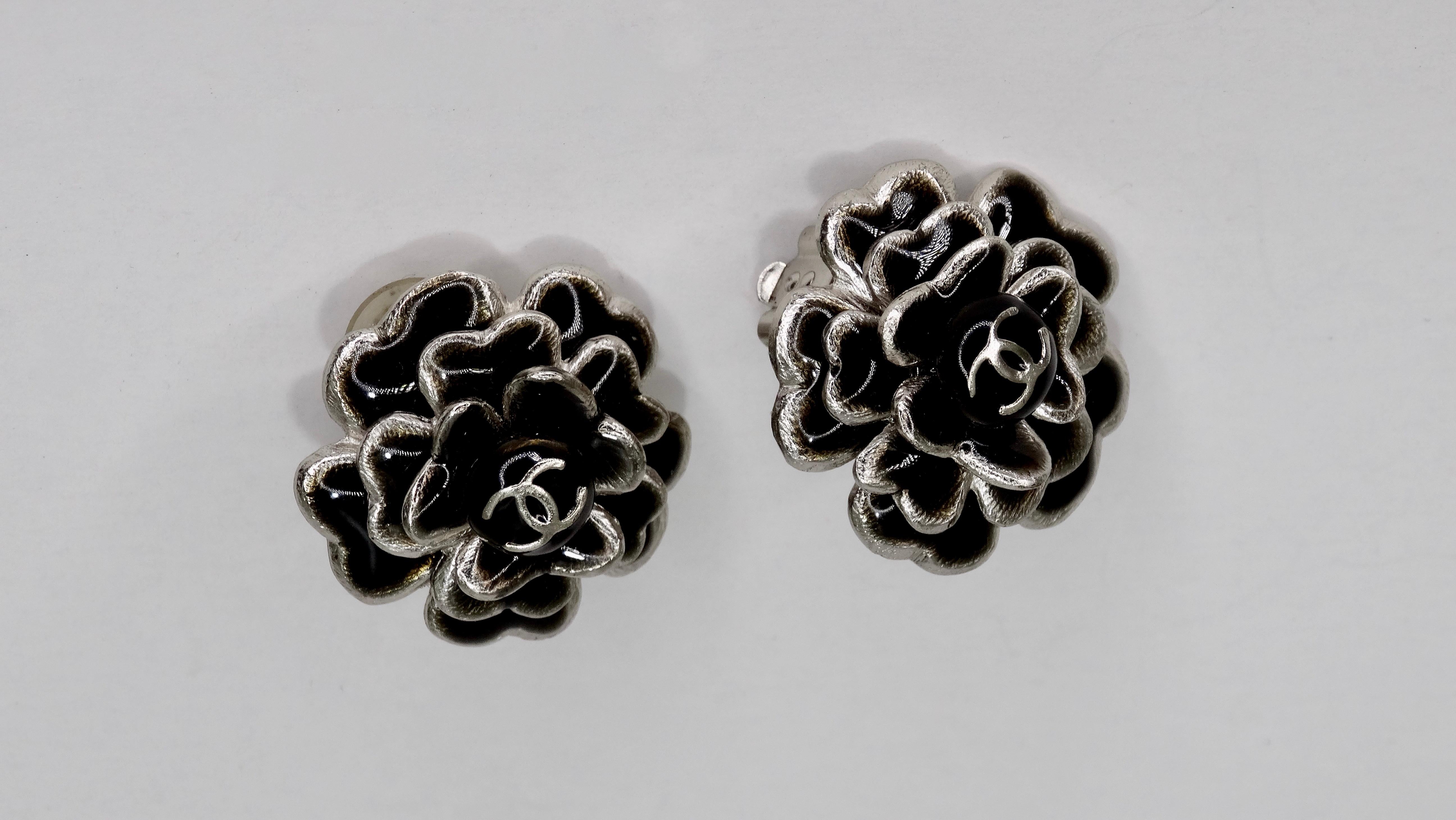 Can you say 'Classic?' Circa 2003 from Chanel's cruise collection, these silver Chanel clip-on earrings feature a black enamel Camellia flower with a CC in the center. These earrings are extremely versatile and can be dressed up or down; pair with