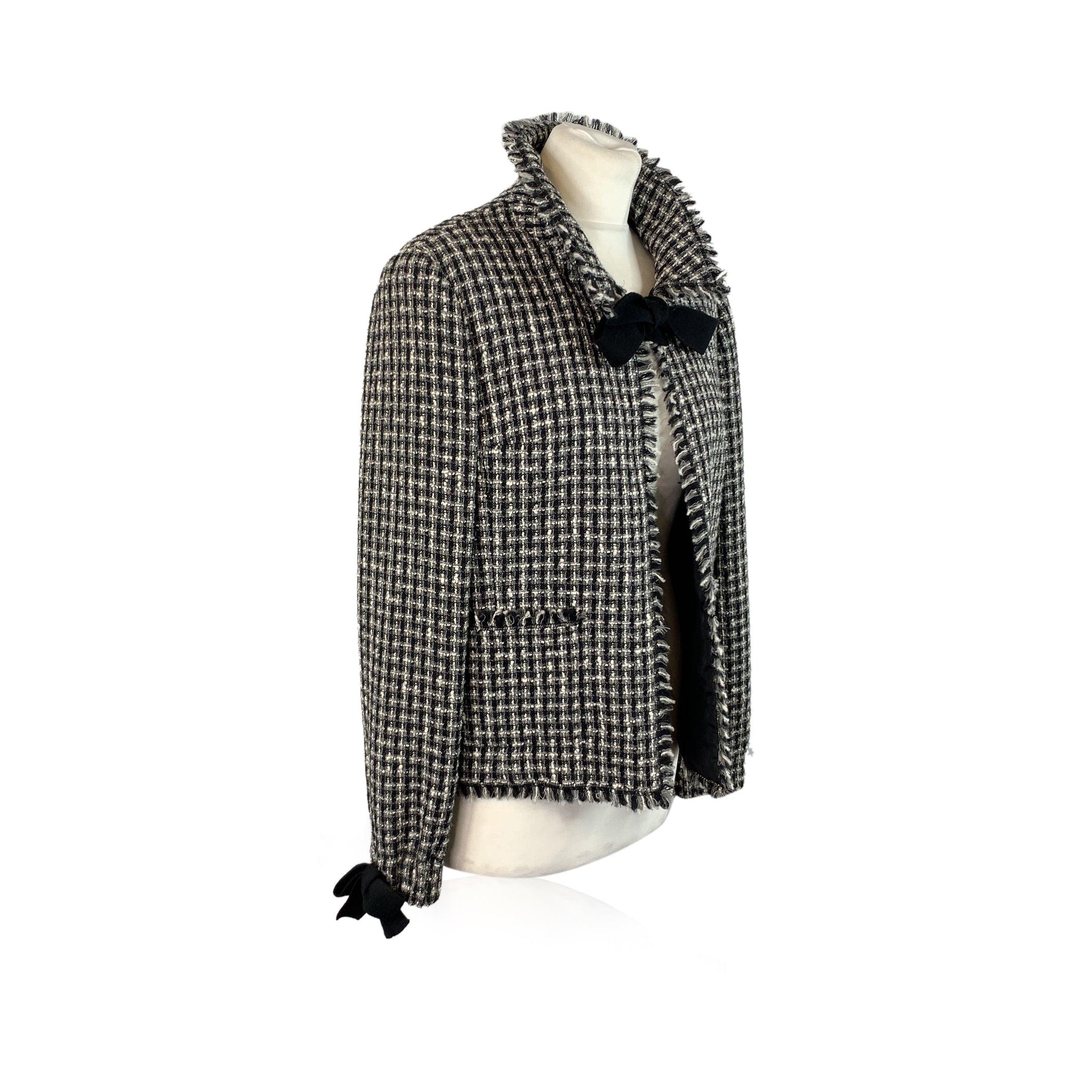 A truly exquisite piece from Chanel's Autumn/Winter 2004 collection, this gorgeous black and white woven Lesage tweed jacket is a breathtaking embodiment of timeless sophistication. This iconic jacket is part of a set that includes a matching skirt,