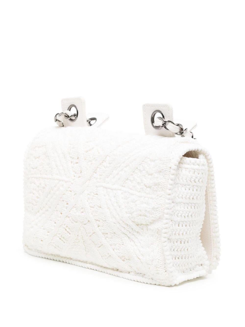 This 2004 Classic Flap Crochet Shoulder Bag provides a stunningly and distinctively crafted look.

* Optical white
* Wool
* Crochet knit
* Two leather and chain-link shoulder straps
* Signature interlocking CC logo
* Signature interlocking CC