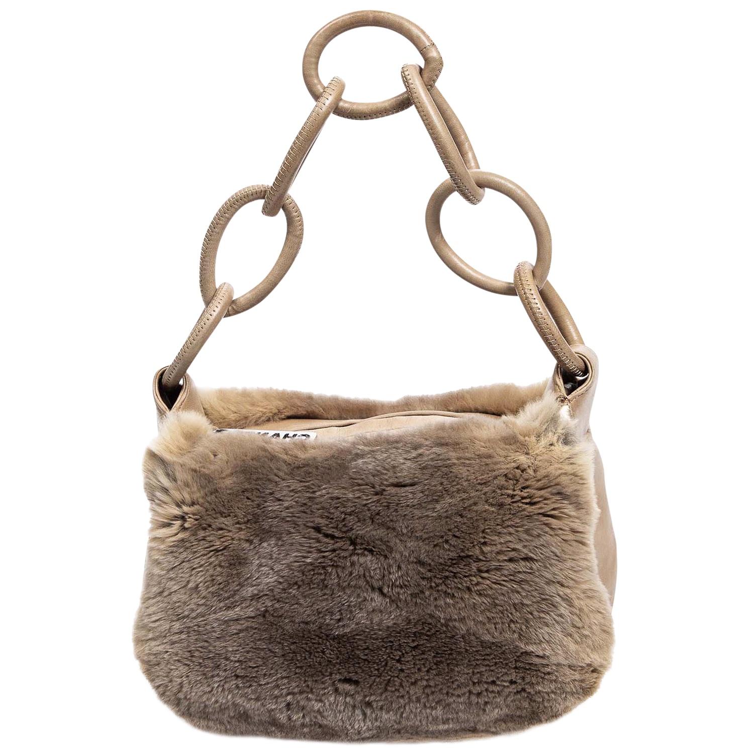 BRRRR it's cold in here! From the Fall 2004 Collection by Karl Lagerfeld, this vintage beauty is crafted in brown fur with tonal leather paneling with an interlocking CC logo & chain-link accent. With silver-tone hardware and a single shoulder strap